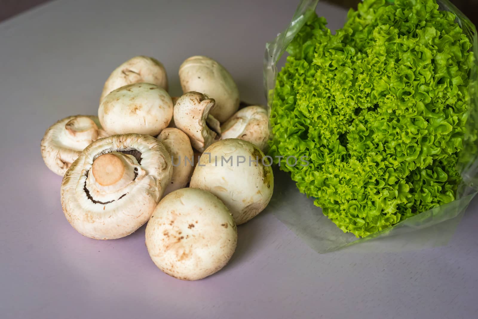 mushrooms and lettuce on a table by okskukuruza