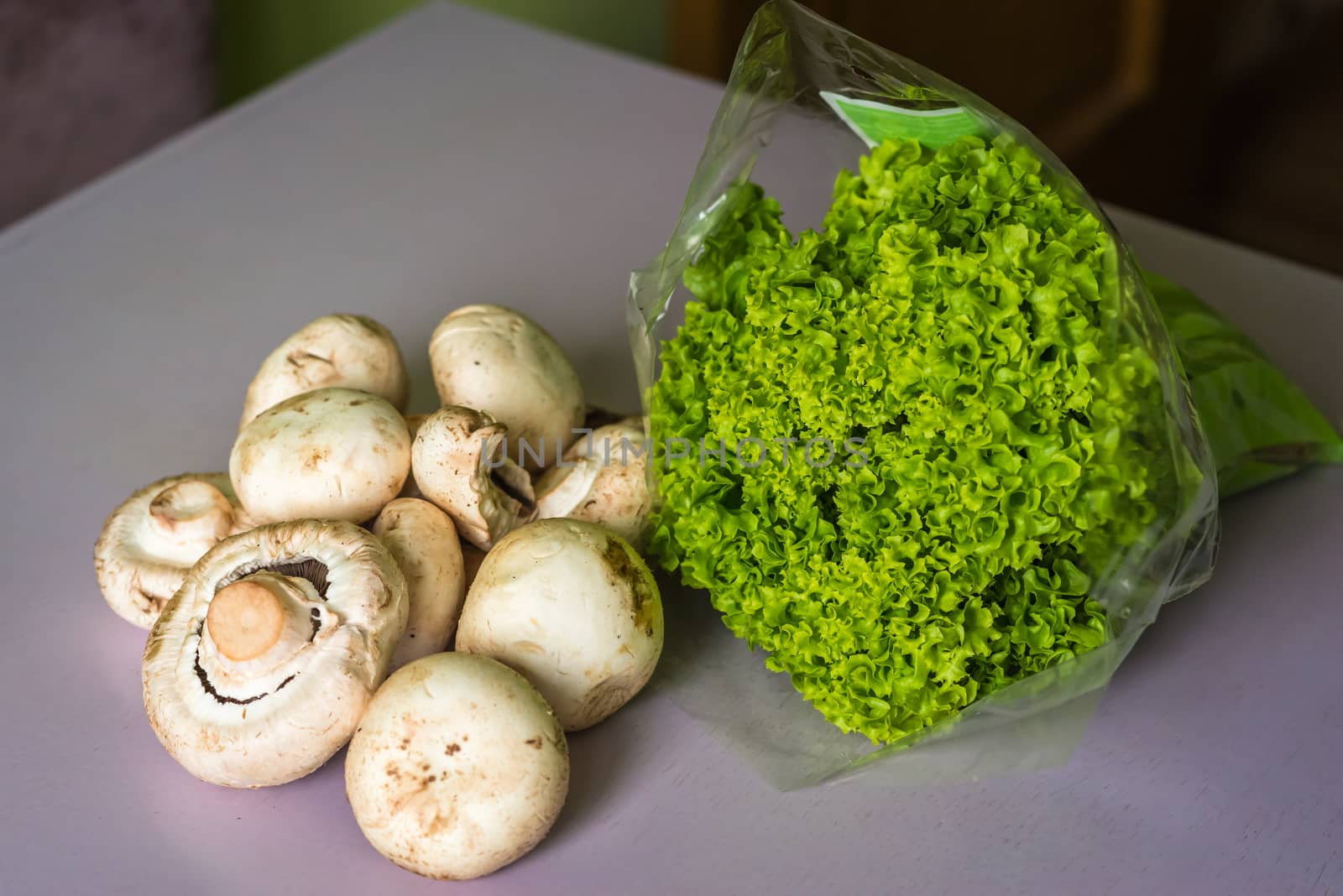 raw and fresh mushrooms and lettuce on the table