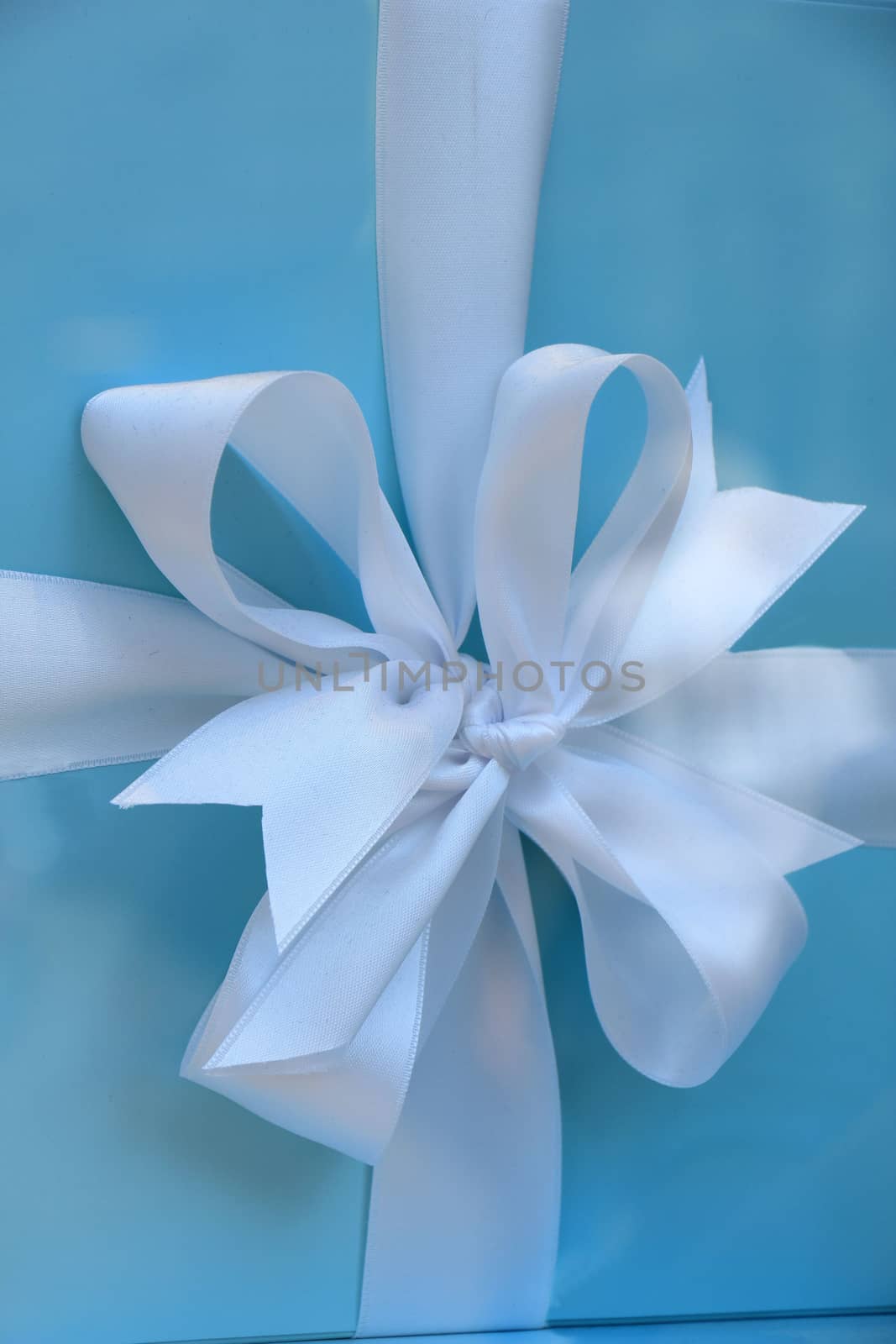 White satin bow on blue giftbox