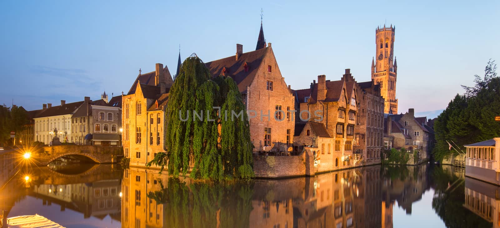 Panorama of Bruges, Belgium. Image with Rozenhoedkaai in Brugge, Dijver river canal and Belfort, Belfry, tower in twilight.