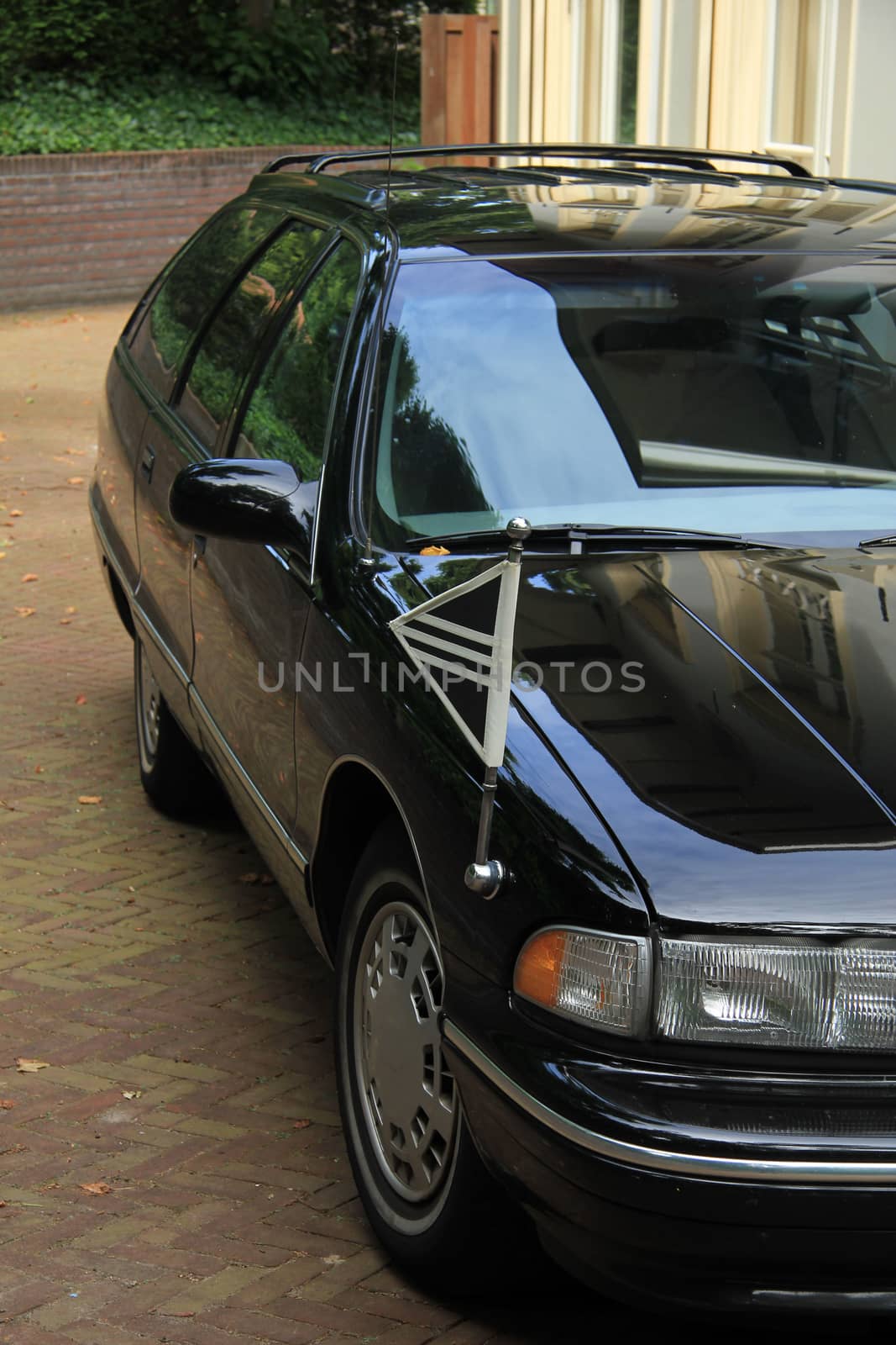 Black hearse, parked outside a funeral home