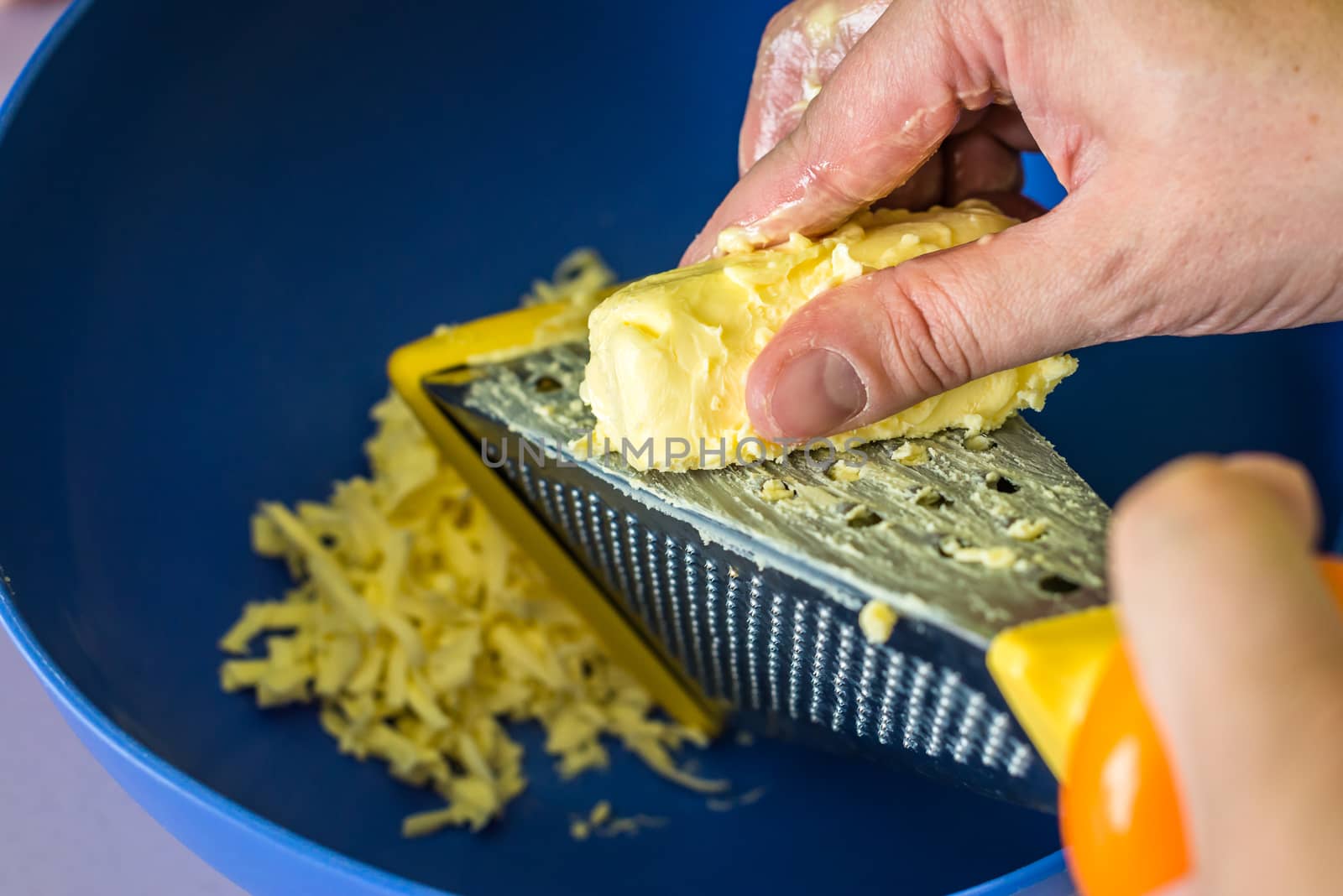 hand shredded cold butter with grated in a blue bowl