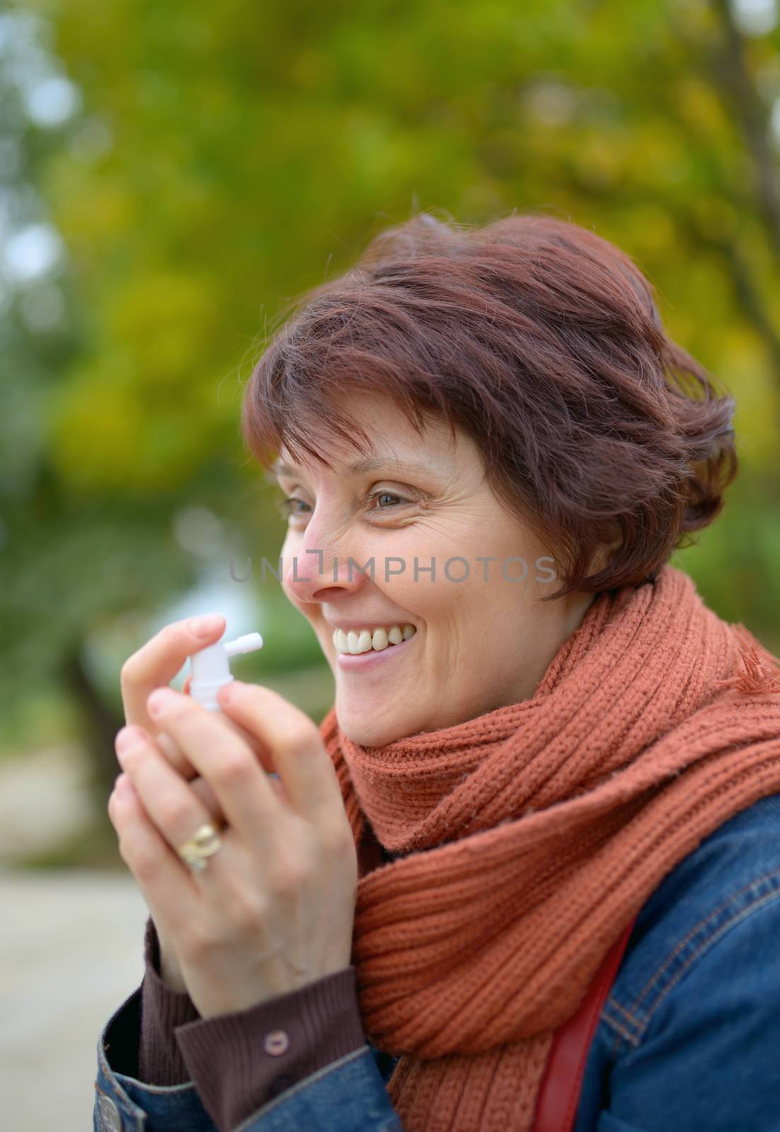 Woman using throat spray in cold season