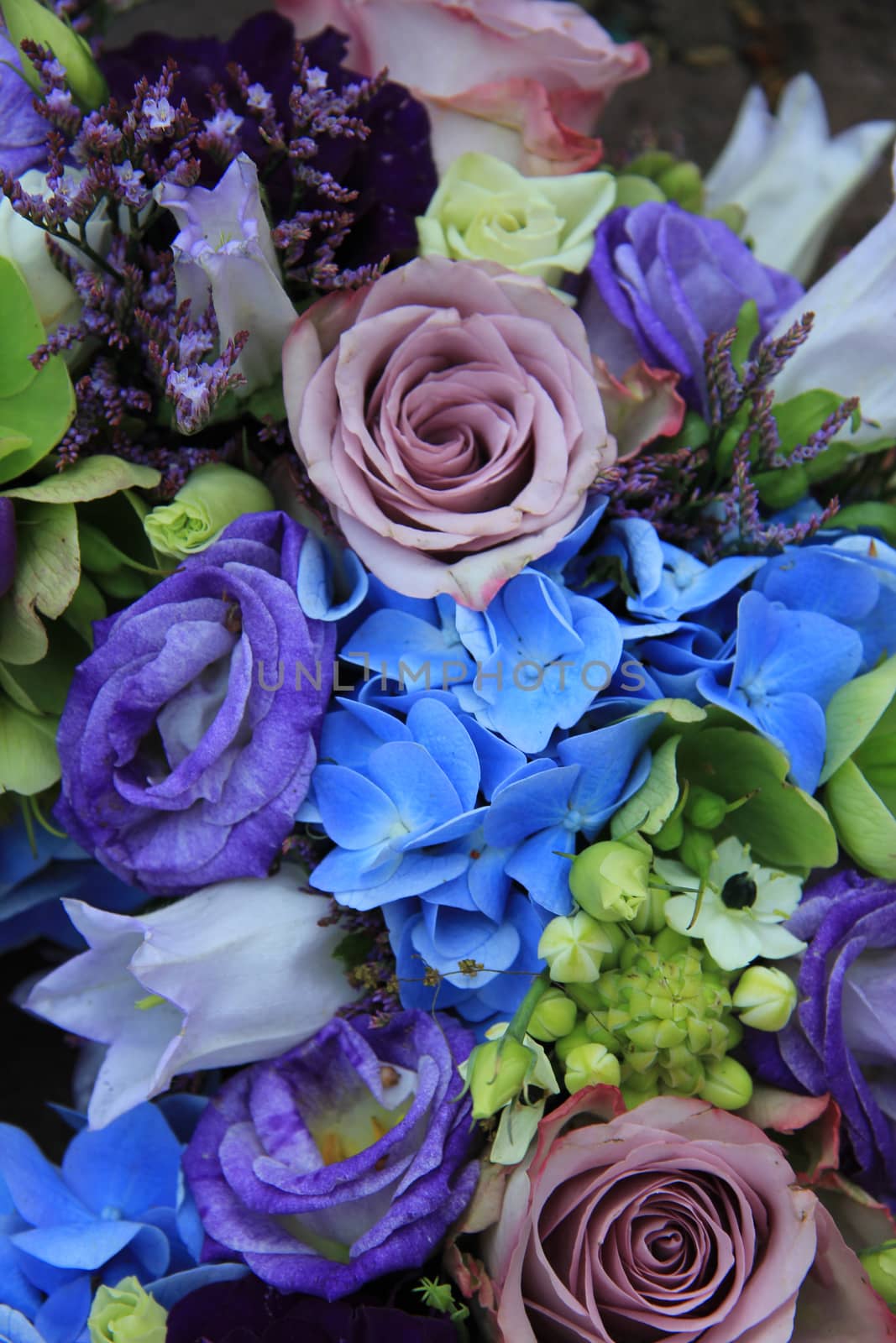 Blue hydragea and purple roses in a blue purple wedding bouquet and centerpieces