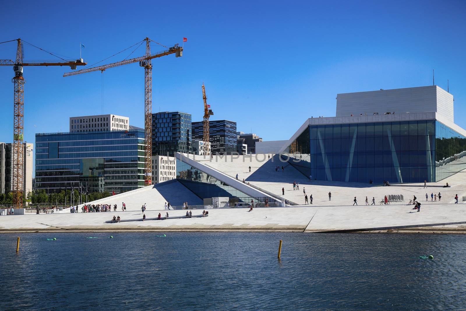 OSLO, NORWAY – AUGUST 17, 2016: Tourist on the Oslo Opera House which is home of Norwegian National Opera and Ballet and National Opera Theatre in Oslo, Norway on August 17,2016.