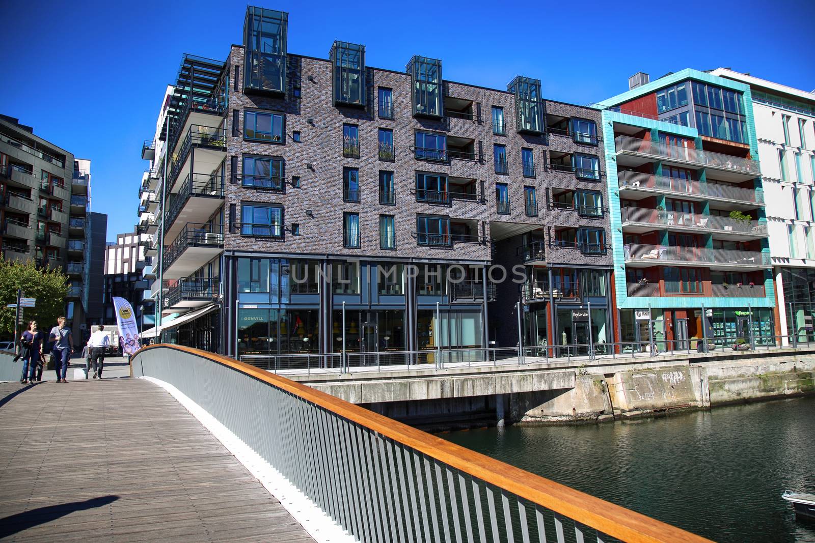 OSLO, NORWAY – AUGUST 17, 2016: People walking on modern district on street Stranden, Aker Brygge district with lux apartments, shopping, culture and restaurants in Oslo, Norway on August 17,2016.
