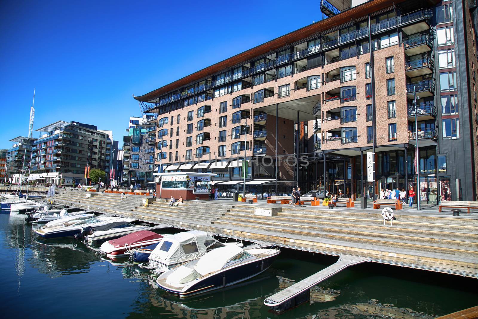 OSLO, NORWAY – AUGUST 17, 2016: People walking on modern district on street Stranden, Aker Brygge district with lux apartments, shopping, culture and restaurants in Oslo, Norway on August 17,2016.