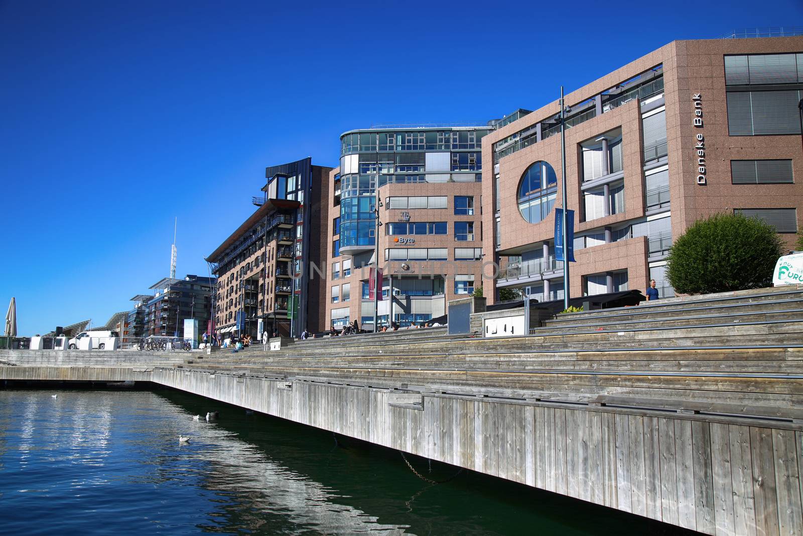 OSLO, NORWAY – AUGUST 17, 2016: People walking on modern district on street Stranden, Aker Brygge district with lux apartments, shopping, culture and restaurants in Oslo, Norway on August 17,2016.