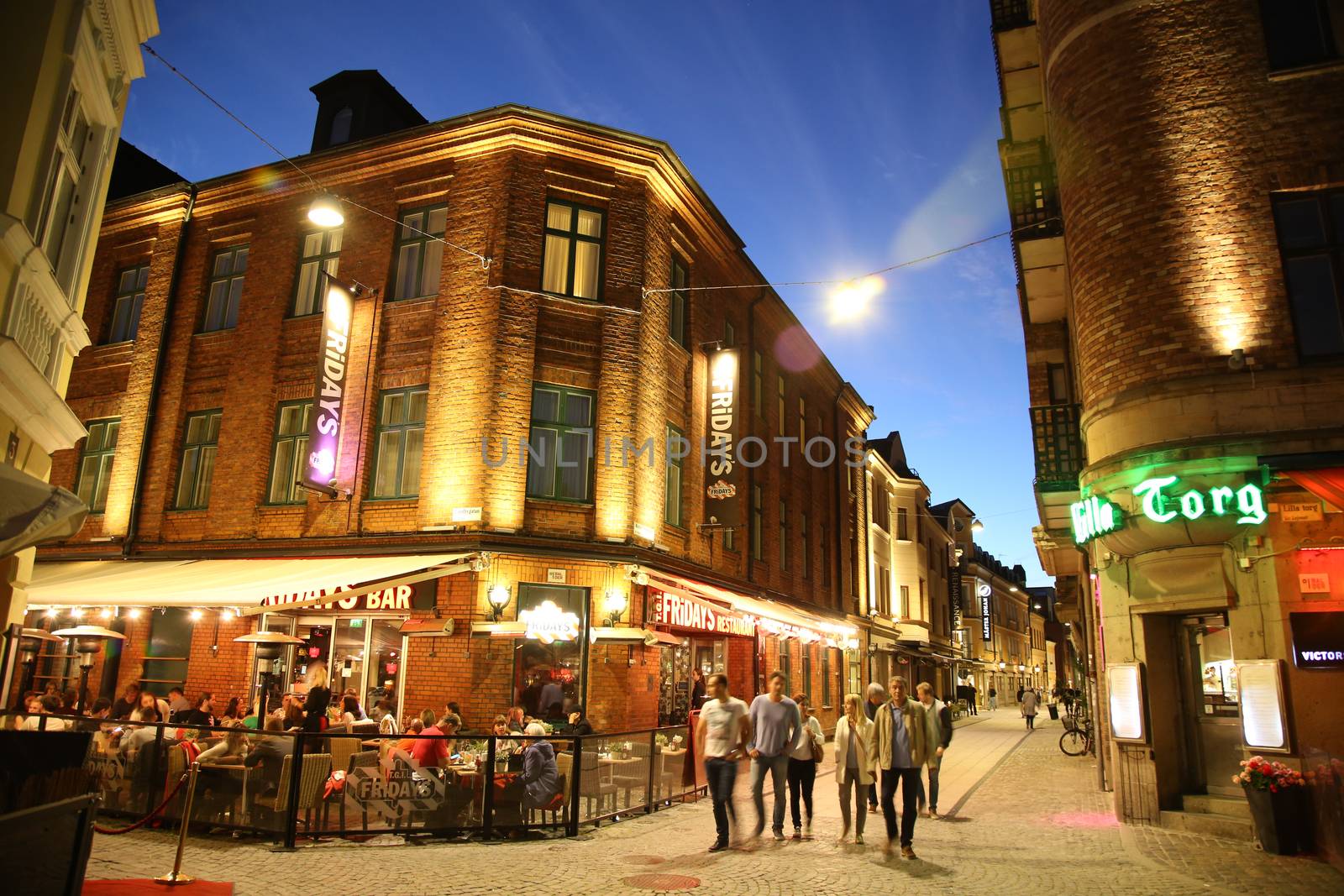 MALMO, SWEDEN - AUGUST 16, 2016: People walk on crossroad of the streets Master Johansgatan, Lilla Torg and Landbygatan street in old part of Malmo, street life in Malmo, Sweden on August 16, 2016.