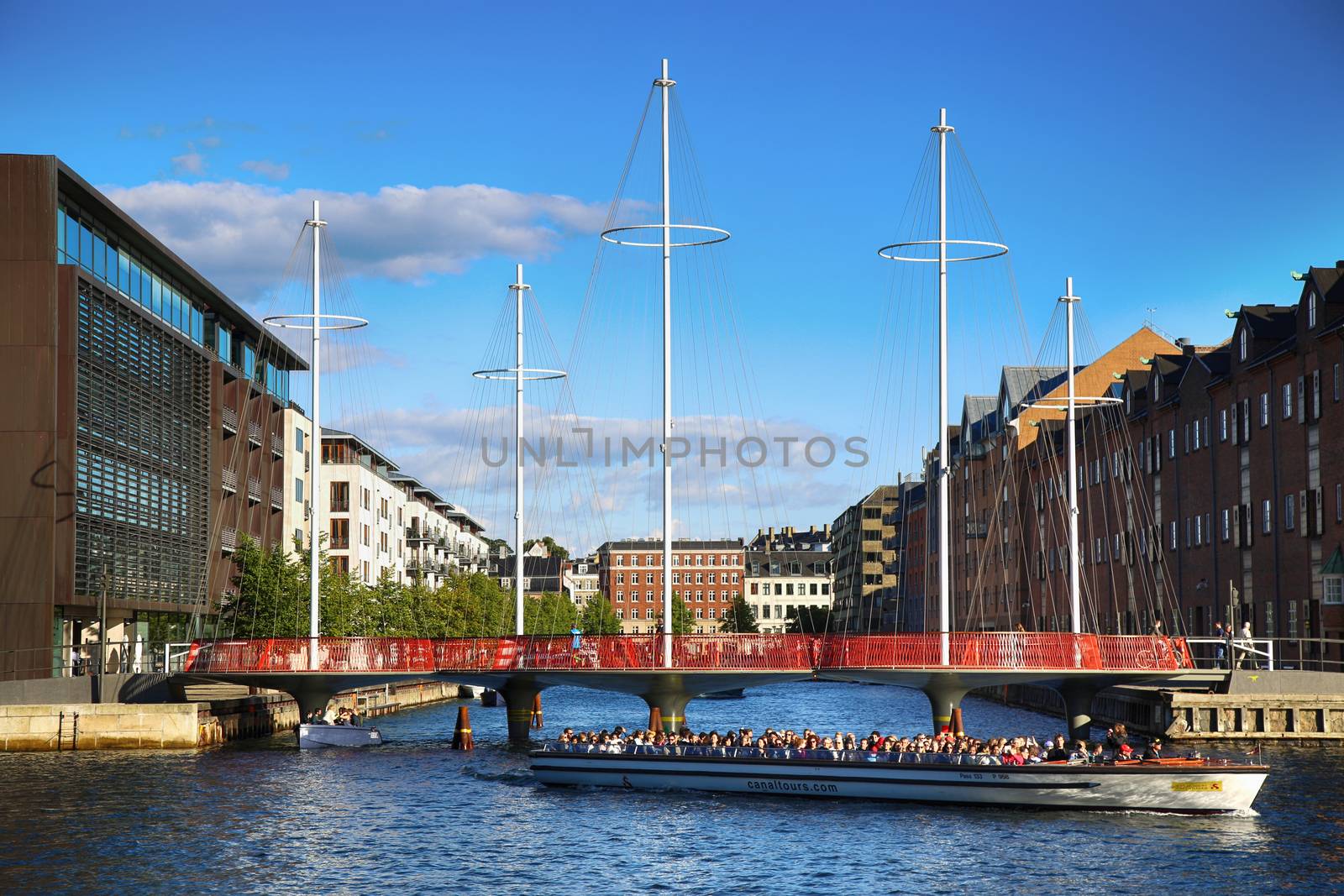 COPENHAGEN, DENMARK - AUGUST  16, 2016:  Beautiful view on the modern Circle Bridge ( Cirkelbroen ) and canal with tourist boat in Copenhagen, Denmark on August 16, 2016.