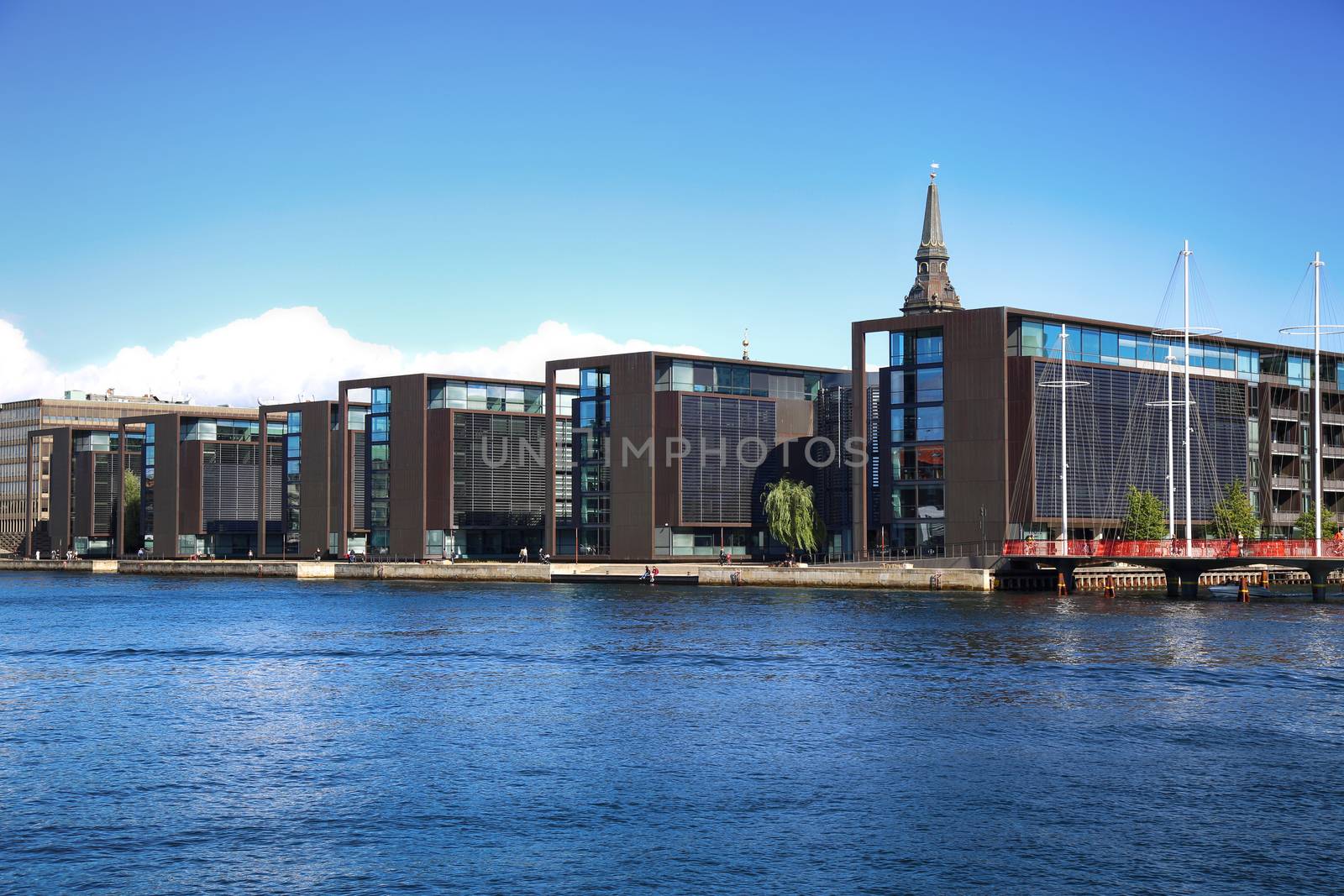 COPENHAGEN, DENMARK - AUGUST  16, 2016:  Beautiful view on Copenhagen waterfront, modern buildings and behind medieval church tower in Copenhagen, Denmark on August 16, 2016.