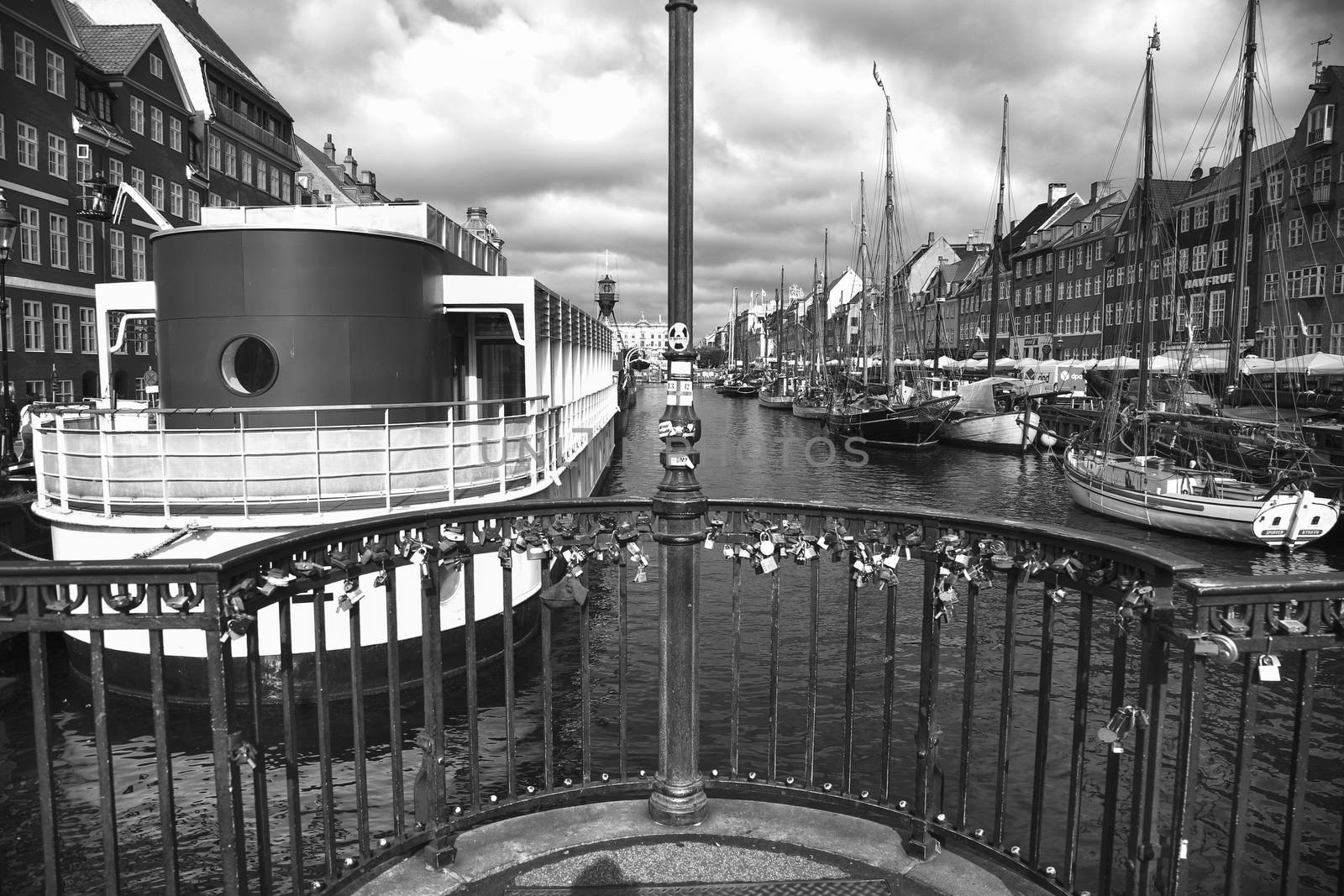 COPENHAGEN, DENMARK - AUGUST 15, 2016: Black and white photo, boats in the docks Nyhavn, people, and colorful architecture. Nyhavn a 17th century harbour in Copenhagen, Denmark on August 15, 2016.