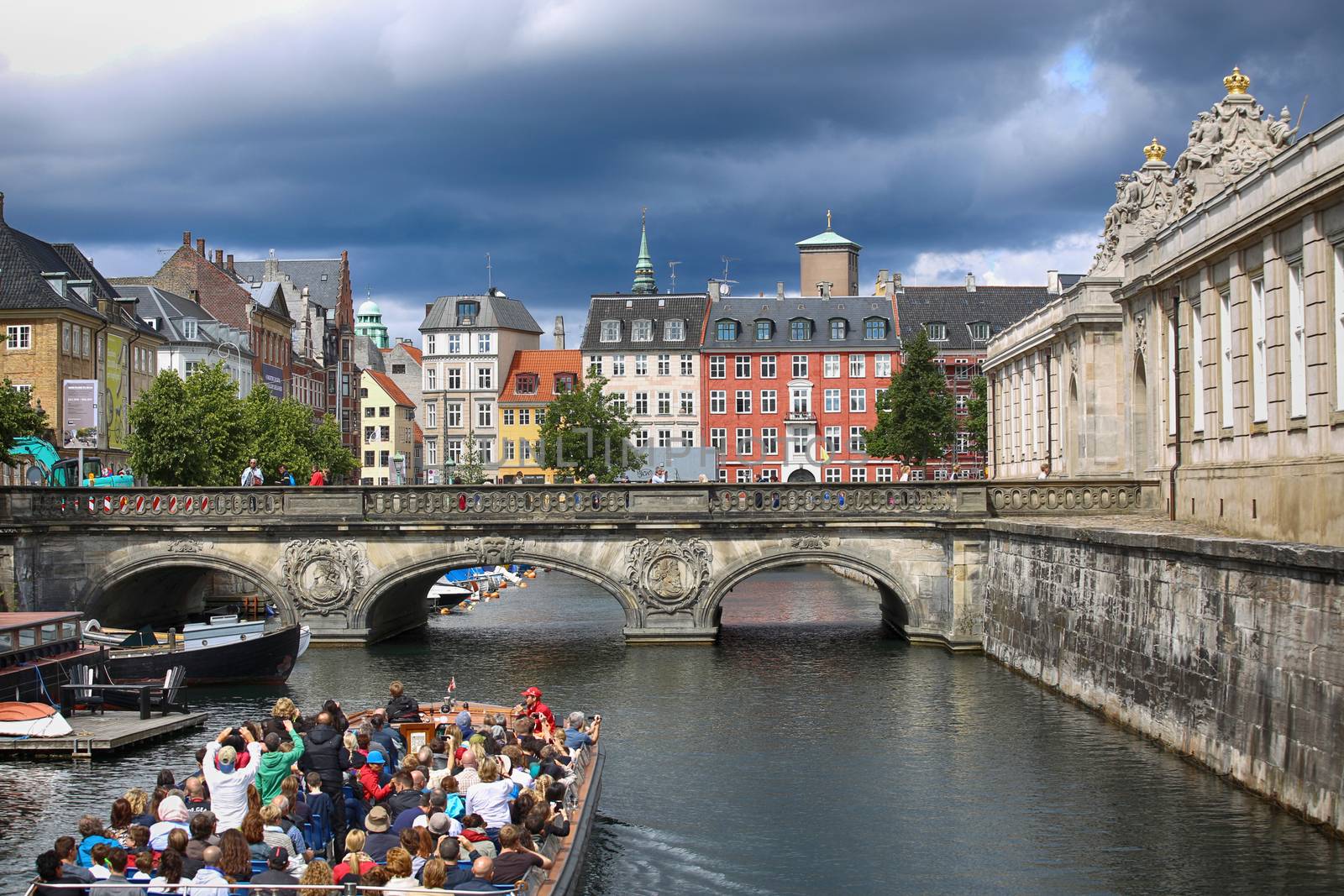 COPENHAGEN, DENMARK - AUGUST 14, 2016: View of canal, boat with tourist and old bridge from bridge Prinsens Bro in Copenhagen, Denmark on August 14, 2016.