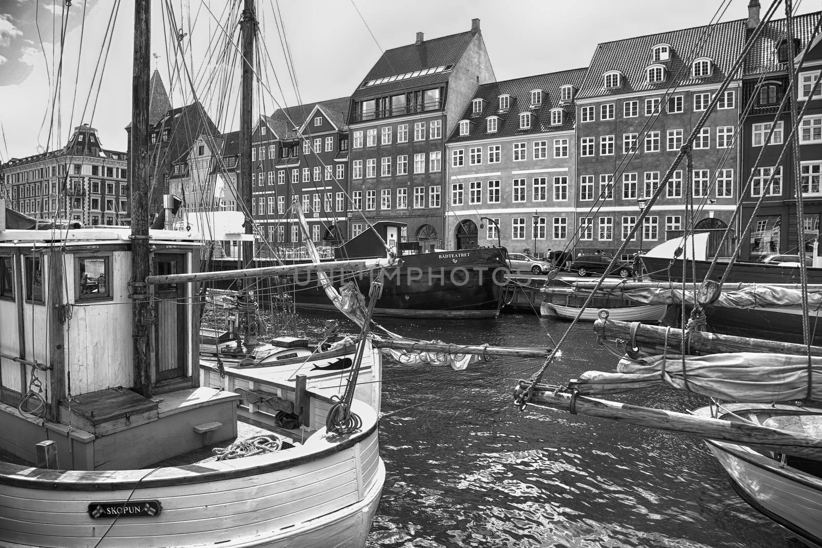 COPENHAGEN, DENMARK - AUGUST 14, 2016: Black and white photo, boats in the docks Nyhavn, people, and colorful architecture. Nyhavn a 17th century harbour in Copenhagen, Denmark on August 14, 2016.