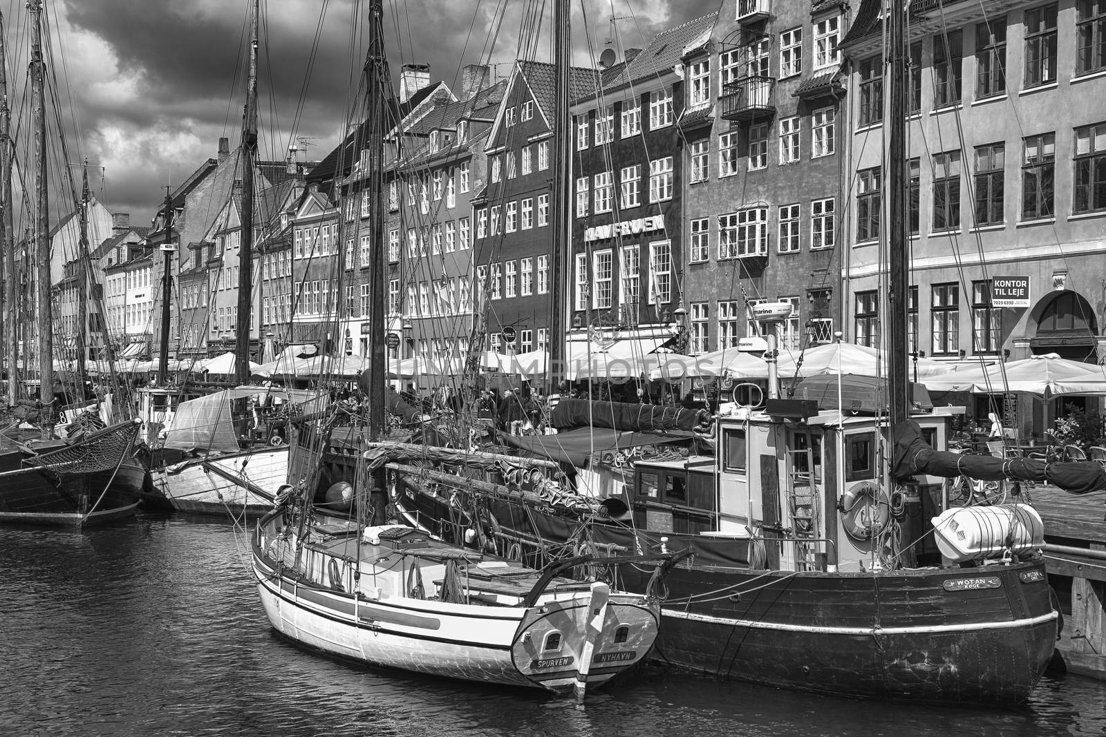 COPENHAGEN, DENMARK - AUGUST 14, 2016: Black and white photo, boats in the docks Nyhavn, people, and colorful architecture. Nyhavn a 17th century harbour in Copenhagen, Denmark on August 14, 2016.