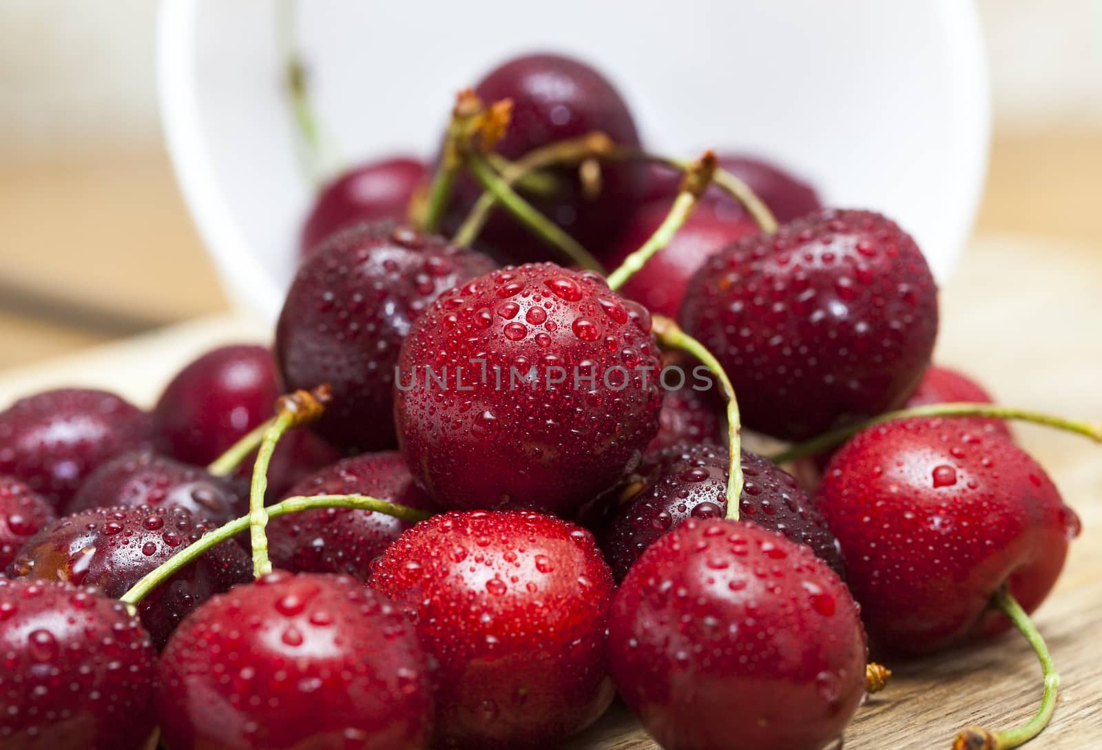 ripe cherry maroon covered with water drops. Berries are together after the harvest. Small depth of field. Photo taken closeup.