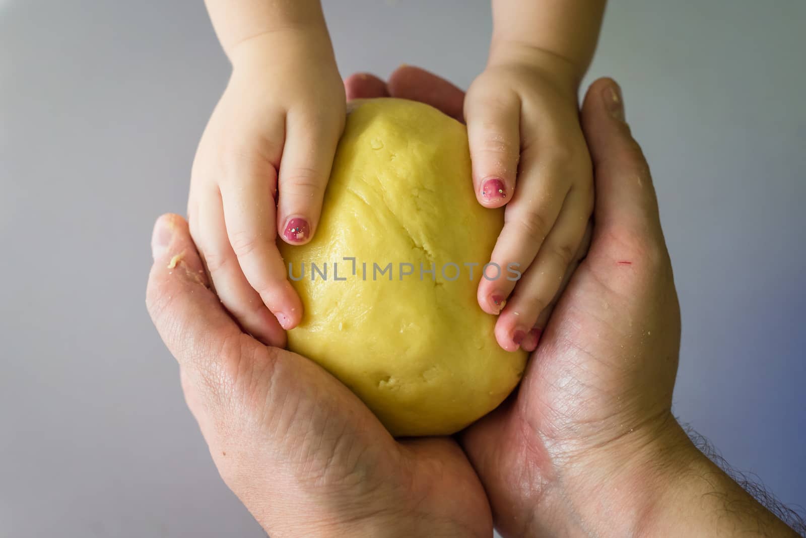 Children and dad hands hold dough by okskukuruza