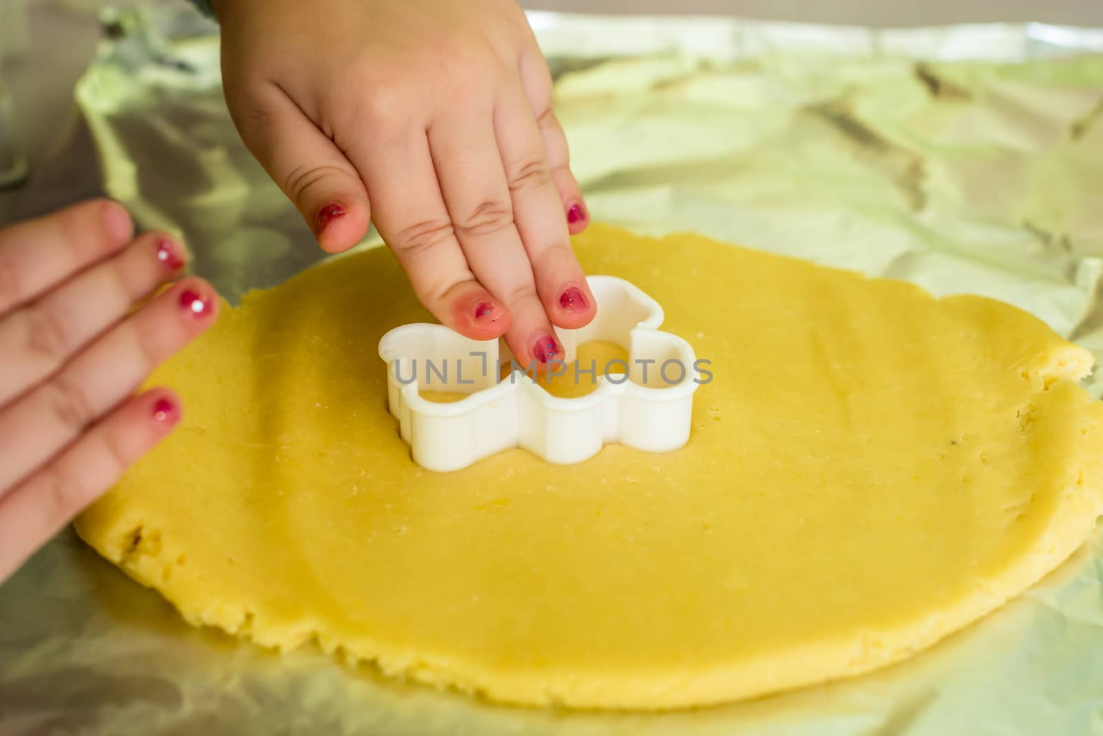 child makes shape of shortcrust dough with cookie cutters