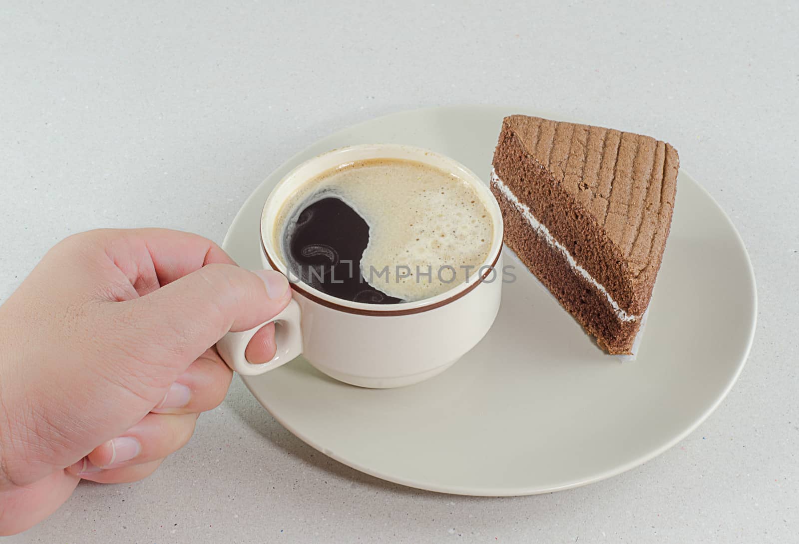 A cup of coffee with slice of chocolate cake on White background