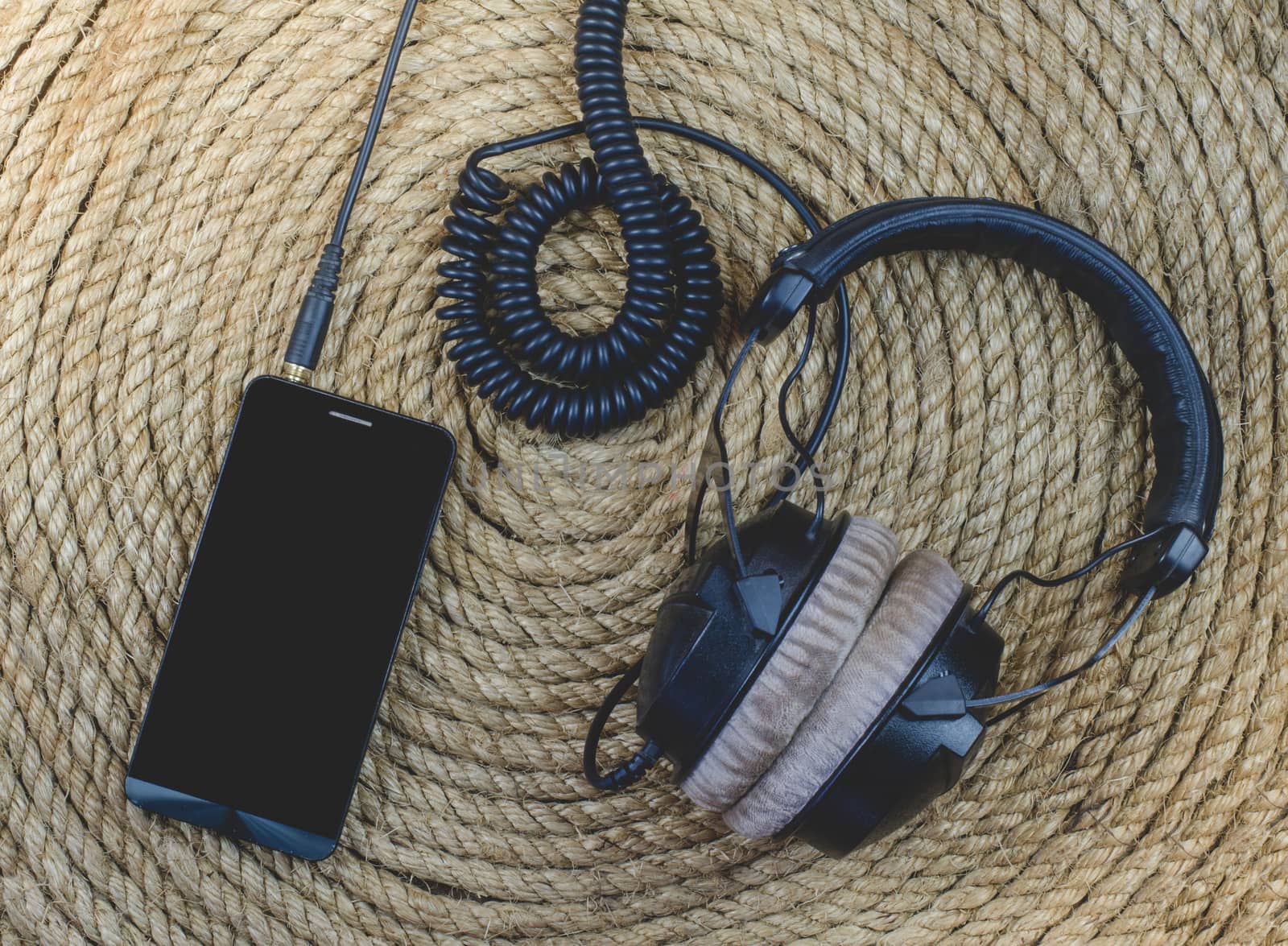 smartphone and headphone music  on a jute rope background by metal22