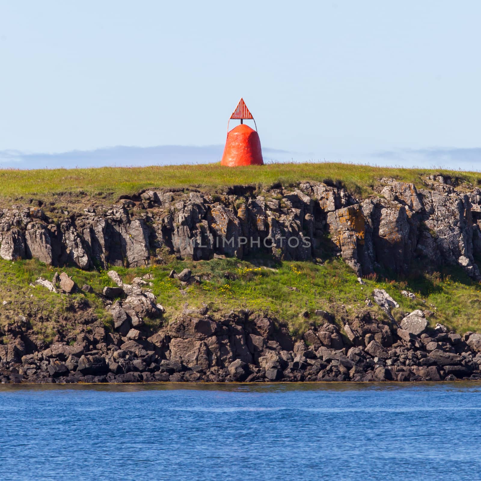 Cute little red lighthouse on a basalt island at the harbor of Stykkisholmur, Iceland