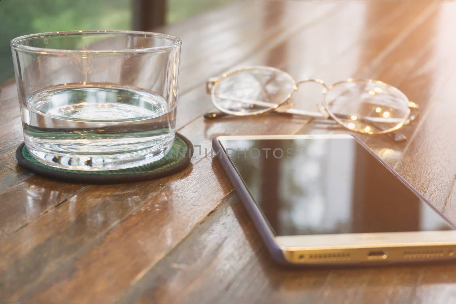 Water glass smartphone Glasses on a wooden table Selective focus. Shallow DOF.