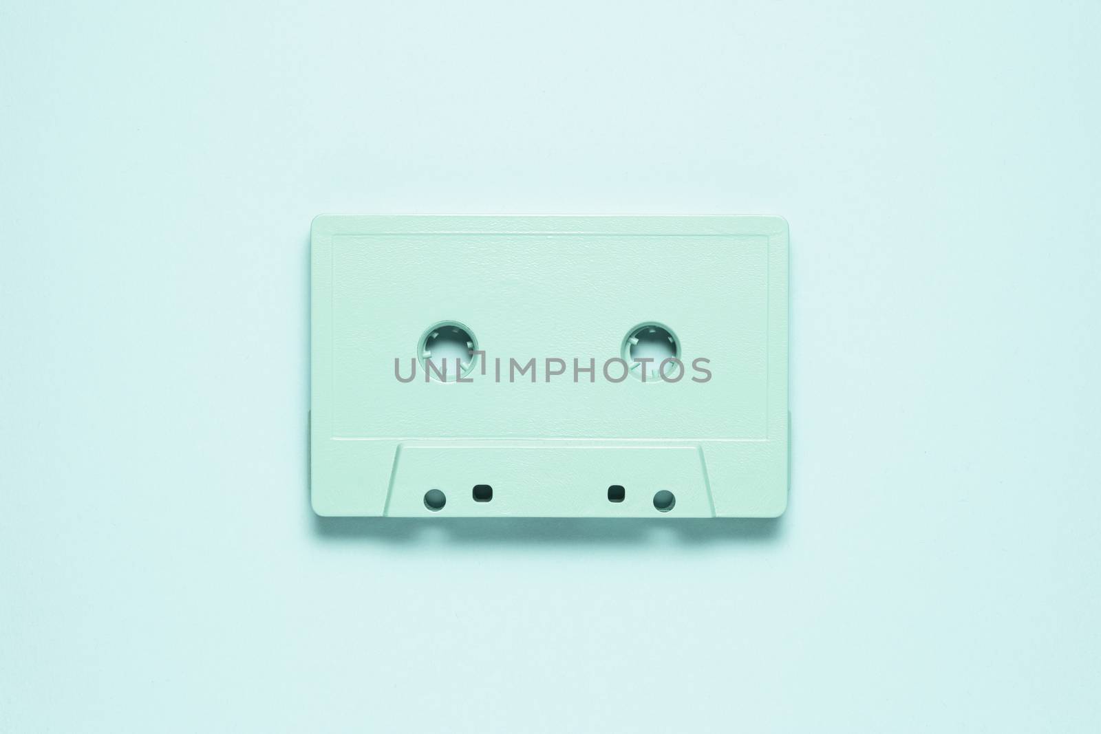 Creative photo of  painted cassette on mint background.