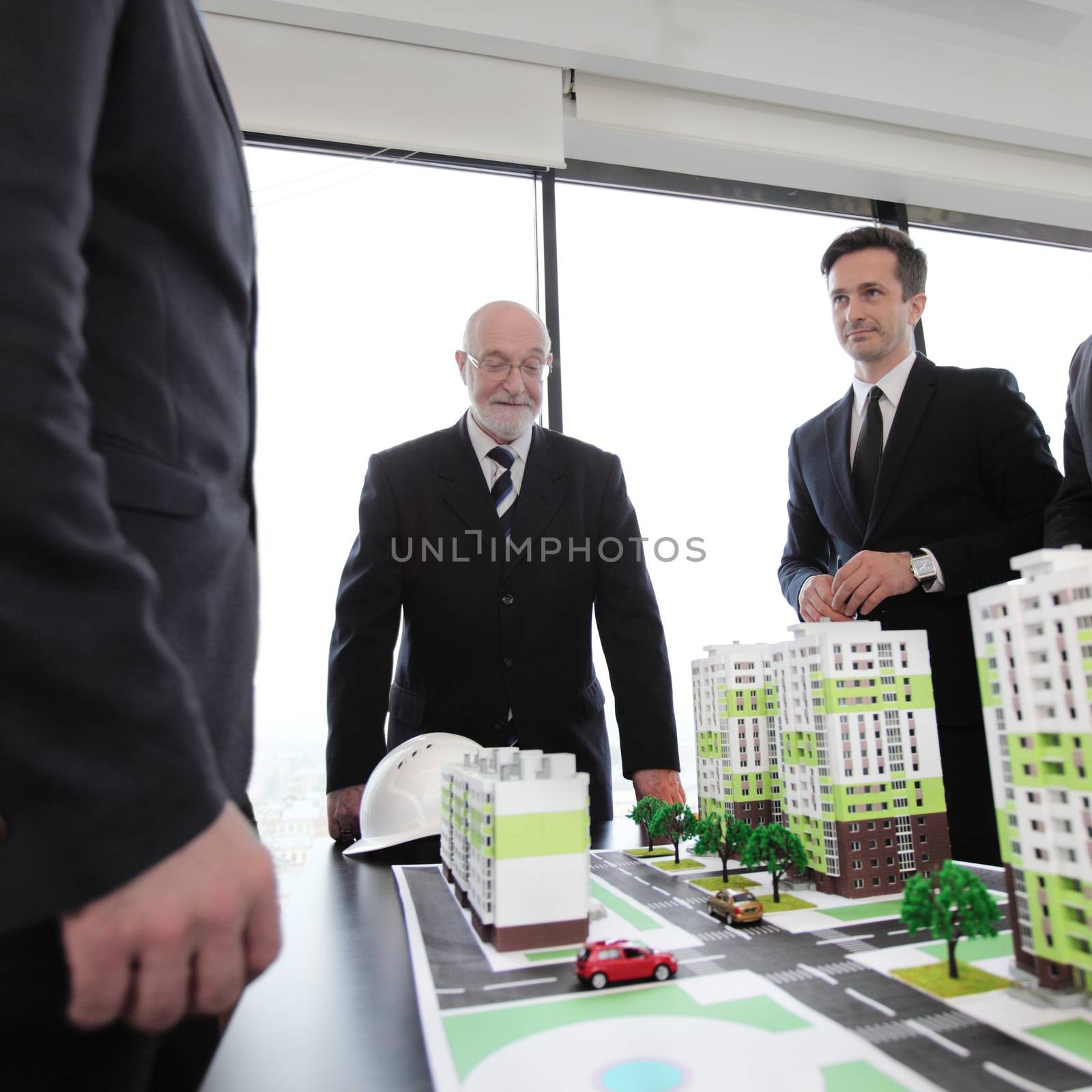 Architects, engineers and business people meeting in office with new house model