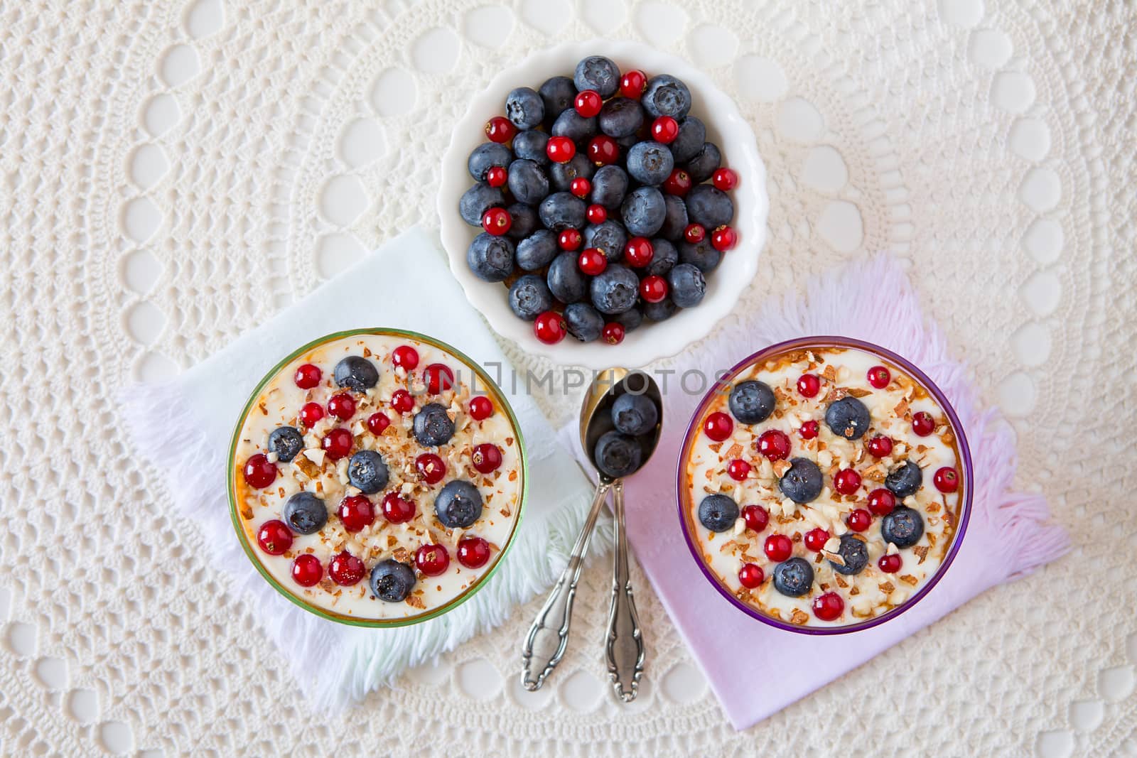 Two yogurt dessert with berries and almonds seen from above