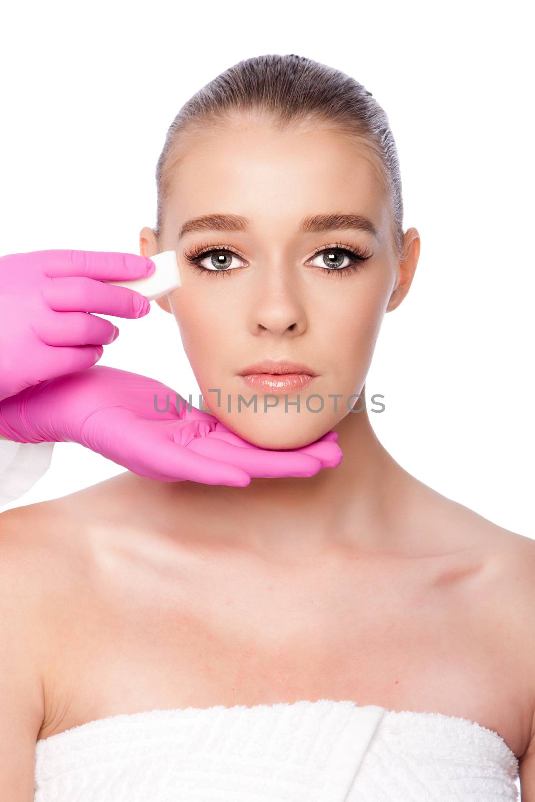 Beautiful face cleansing Cosmetic skincare spa beauty treatment with pink gloves and sponge, on white.