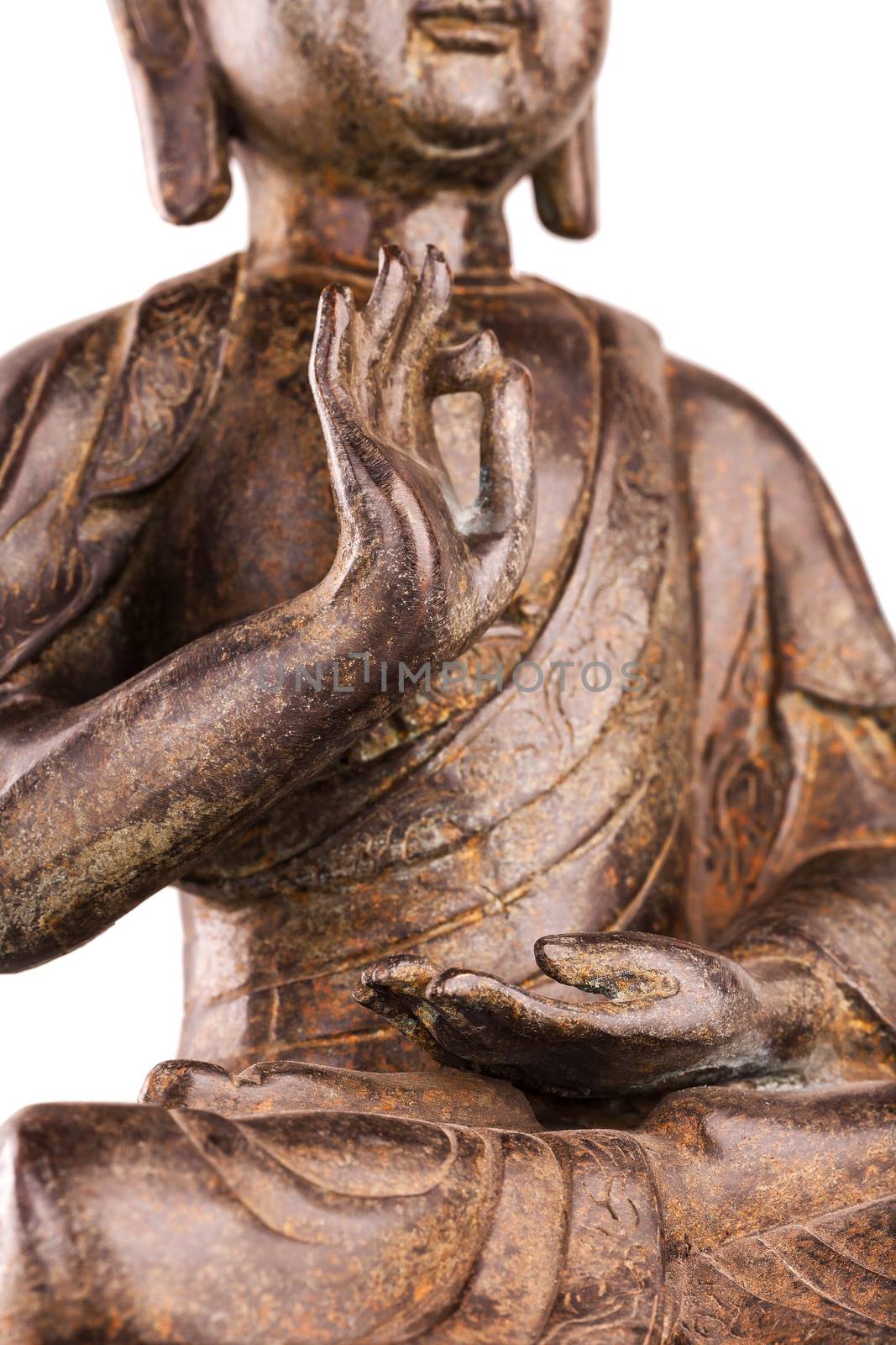 Buddha Shakyamuni's figure in a manual pose - vitarka mudra. The old statue made of metal isolated on a white background.