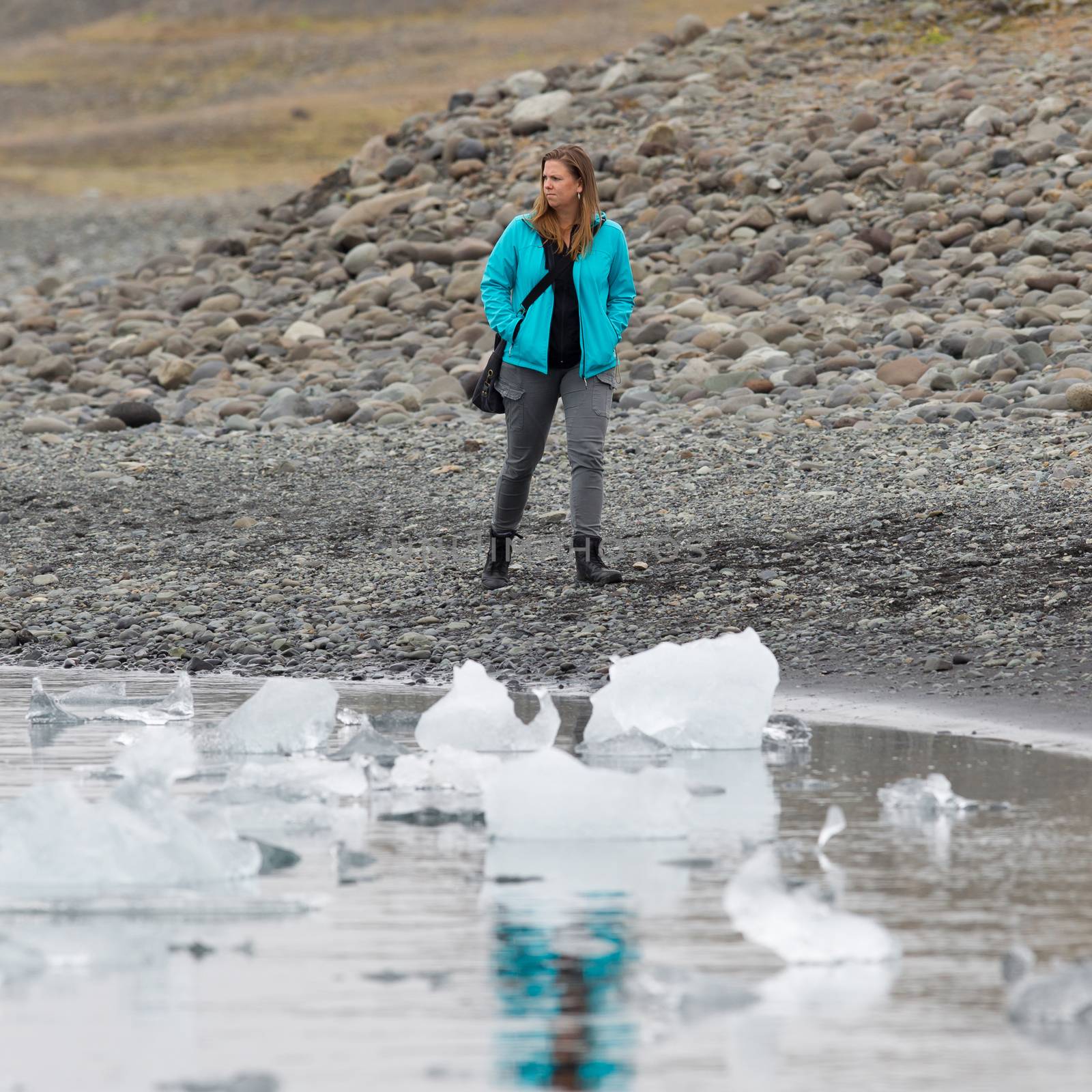Woman walking over the beach at Jokulsarlon glacier lagoon in southern Iceland