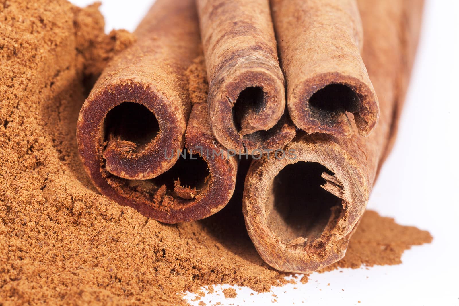 Cinnamon sticks and powder isolated on white background, close up.