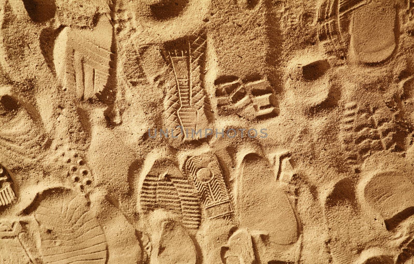 prints from various footwear on sand by ssuaphoto