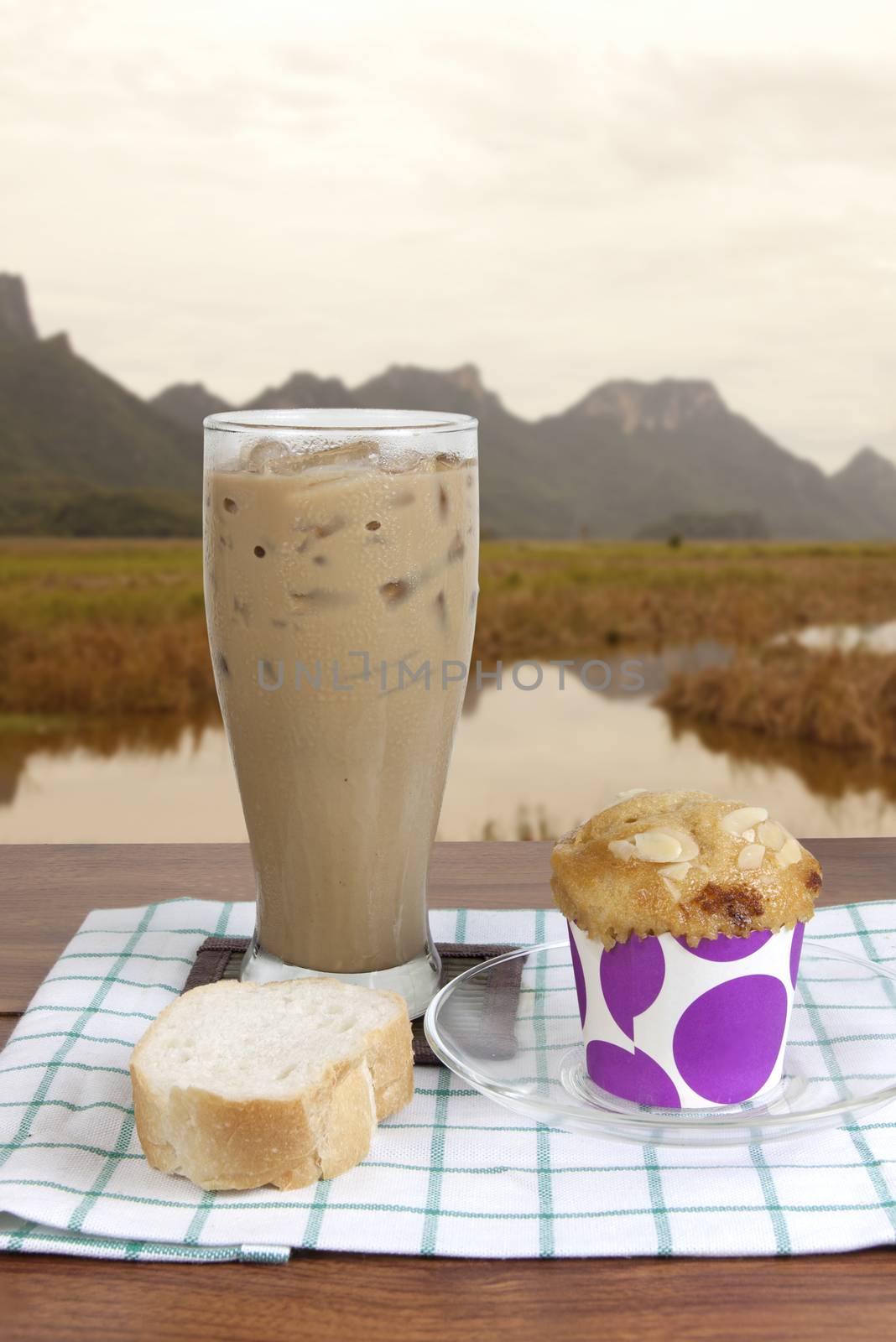 Cocoa chocolate smoothie in glass and French bread baguette and muffin in the morning. Nature background