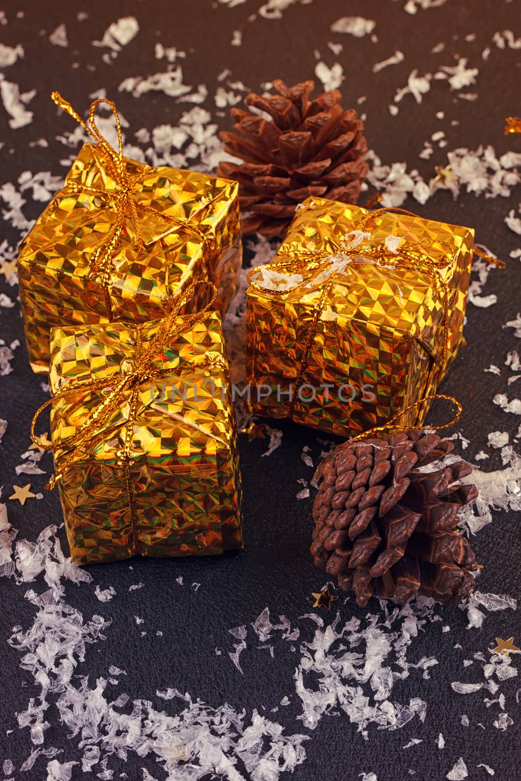 christmas gift boxes with spruce twigs and cones on black