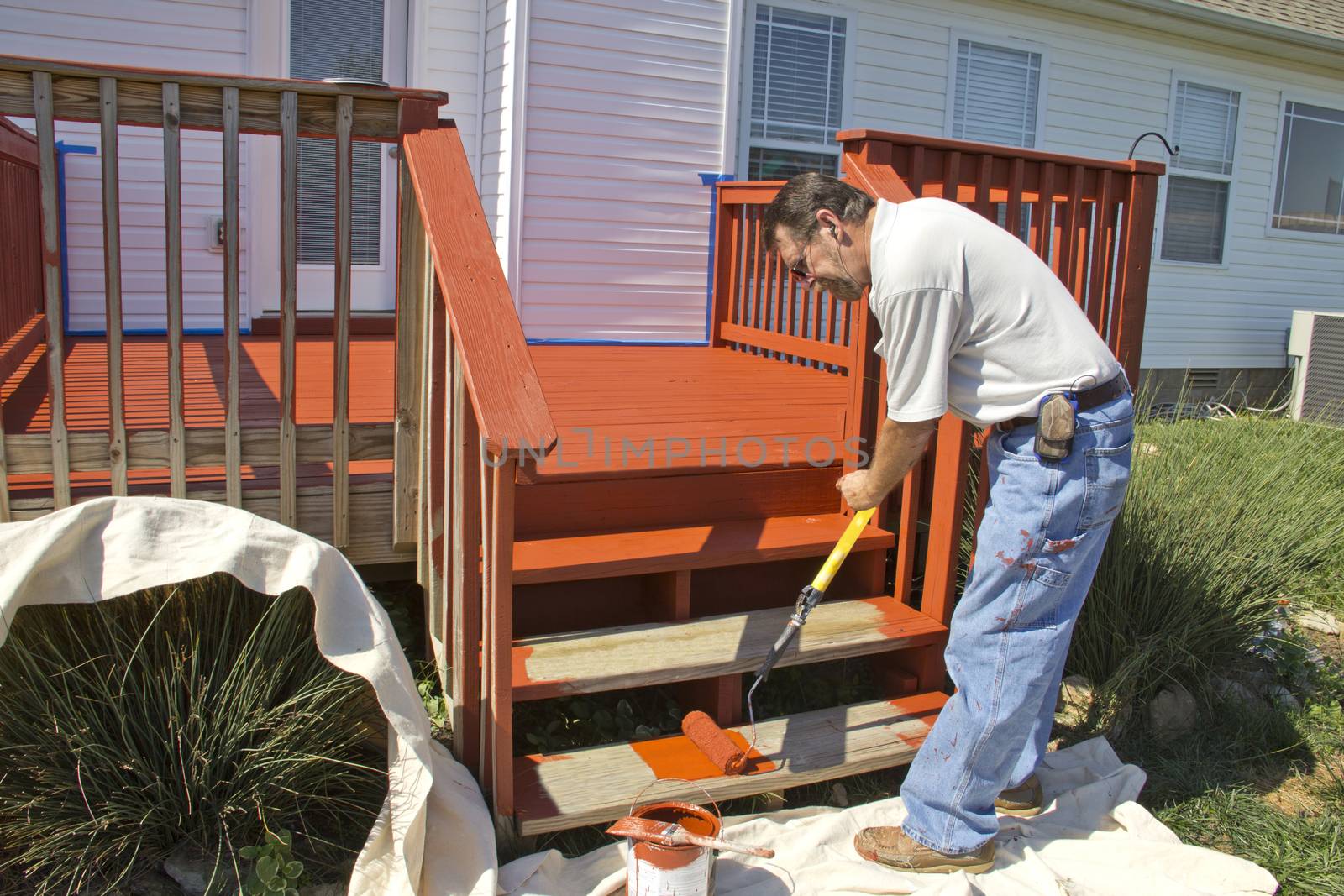 Contract painter staining deck on home to protect it from the weather