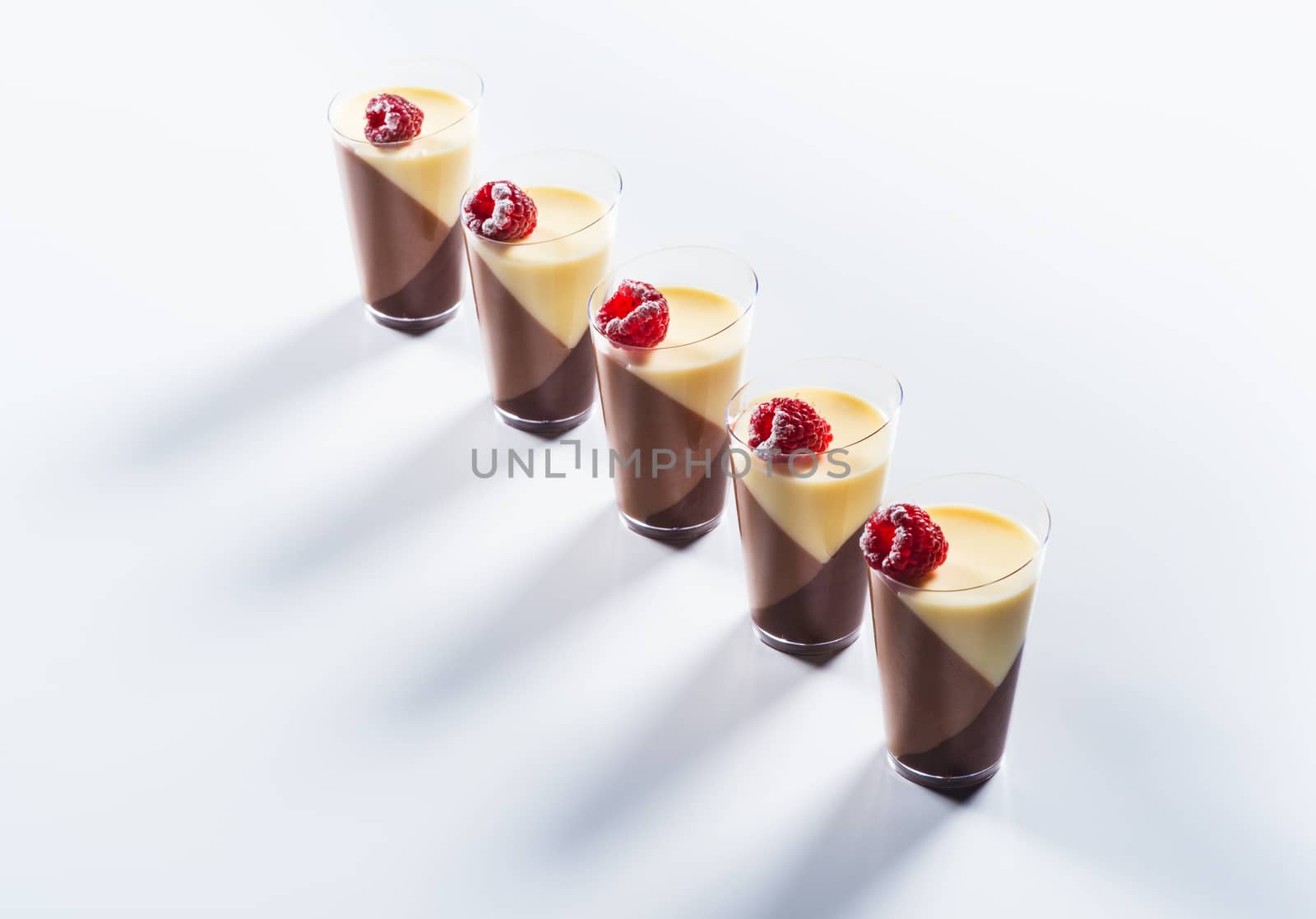 Tricolor pana cotta in the cup on light background