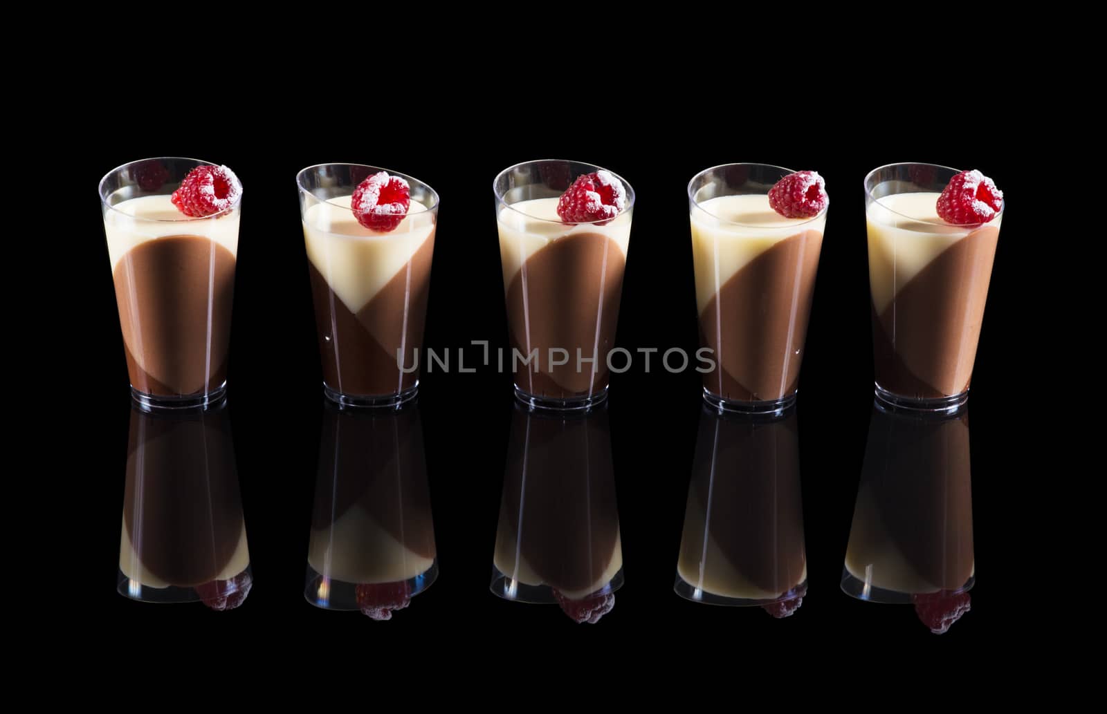 Tricolor pana cotta in the cup on black background