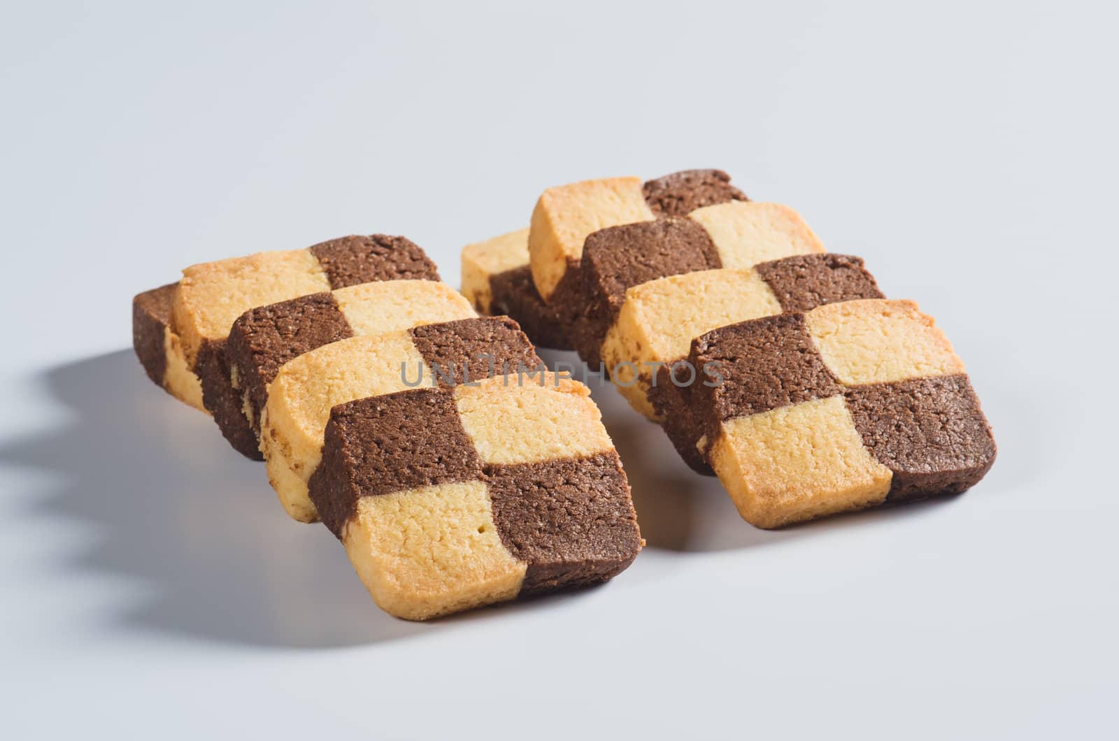 Lots bicolour square shortbread biscuits on light background