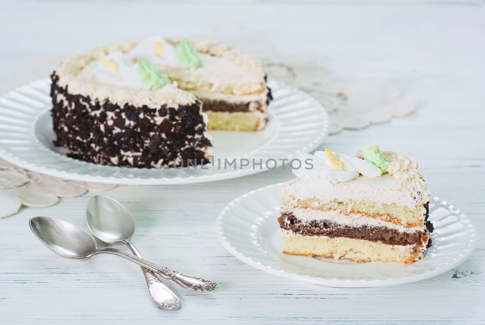 Creamy cake on plate on table on light background, selective focus.