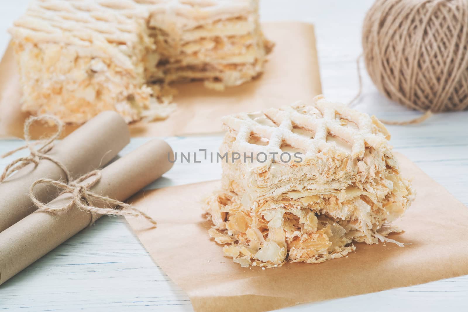 Puff cake on baking paper on table on light background