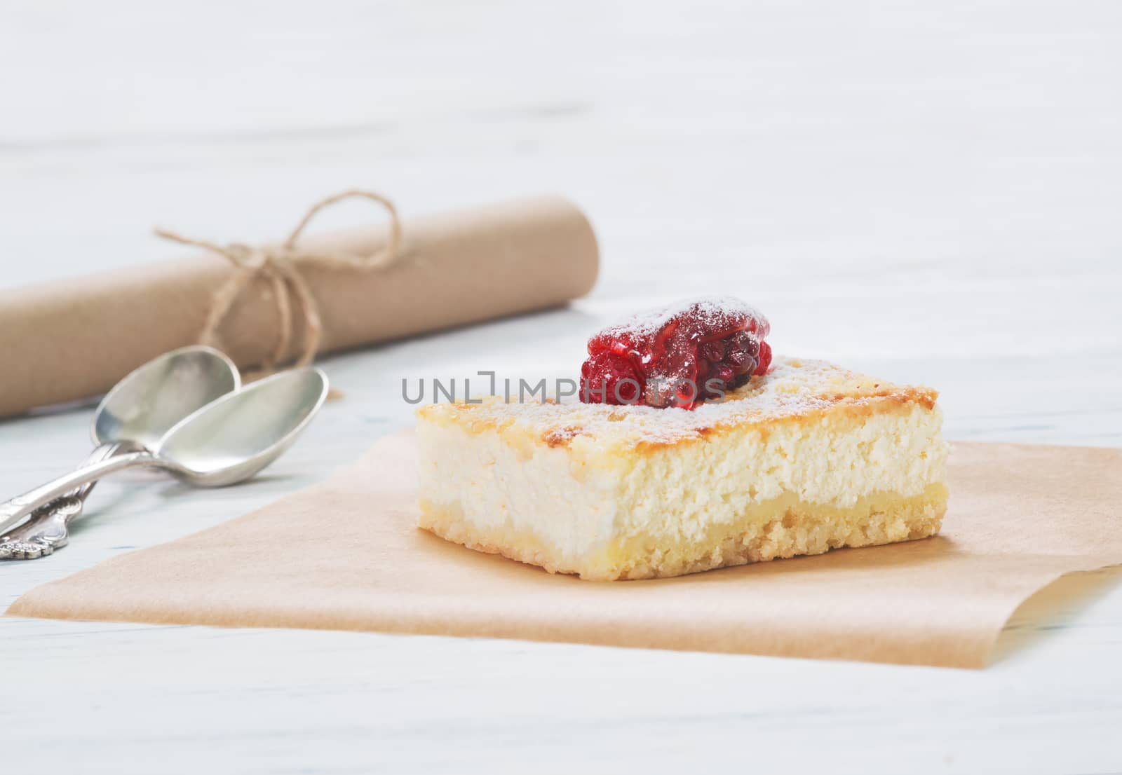 Cheesecake on baking paper on light background