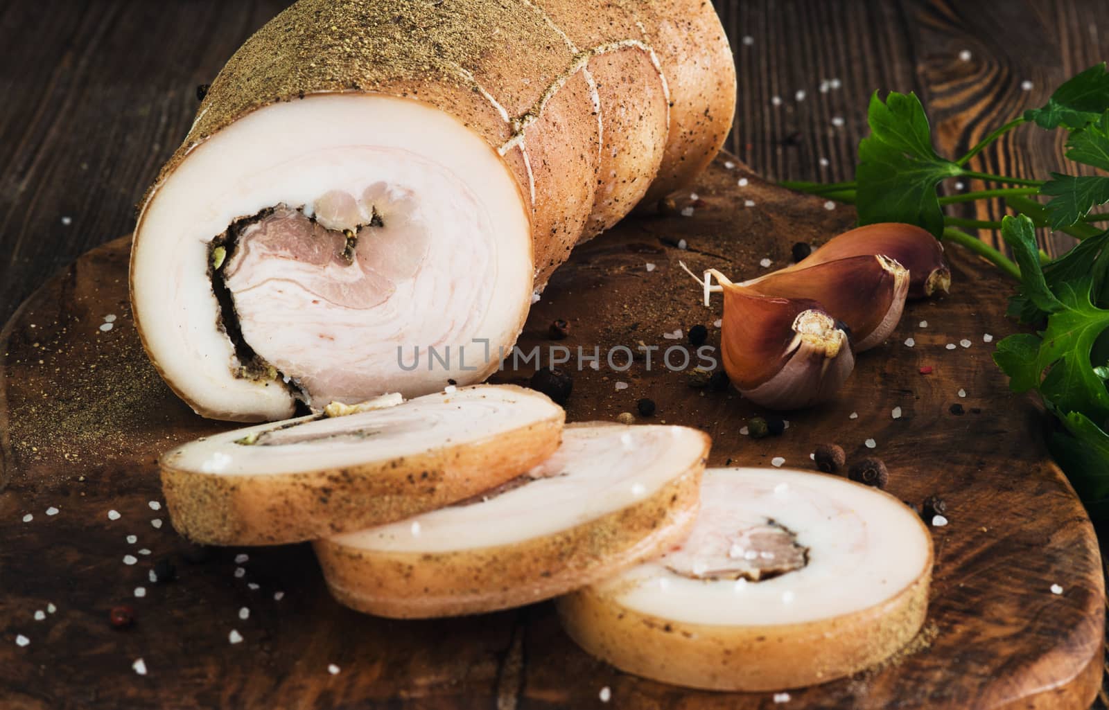 Lard roll with salt and garlic, wooden background