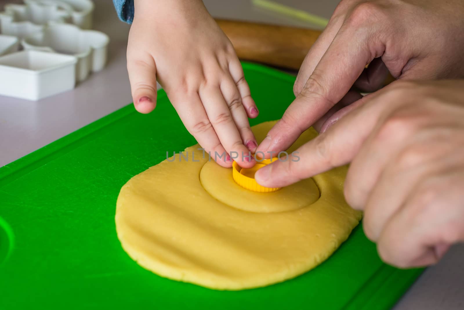 child and dad makes shape of shortcrust dough bottle cap