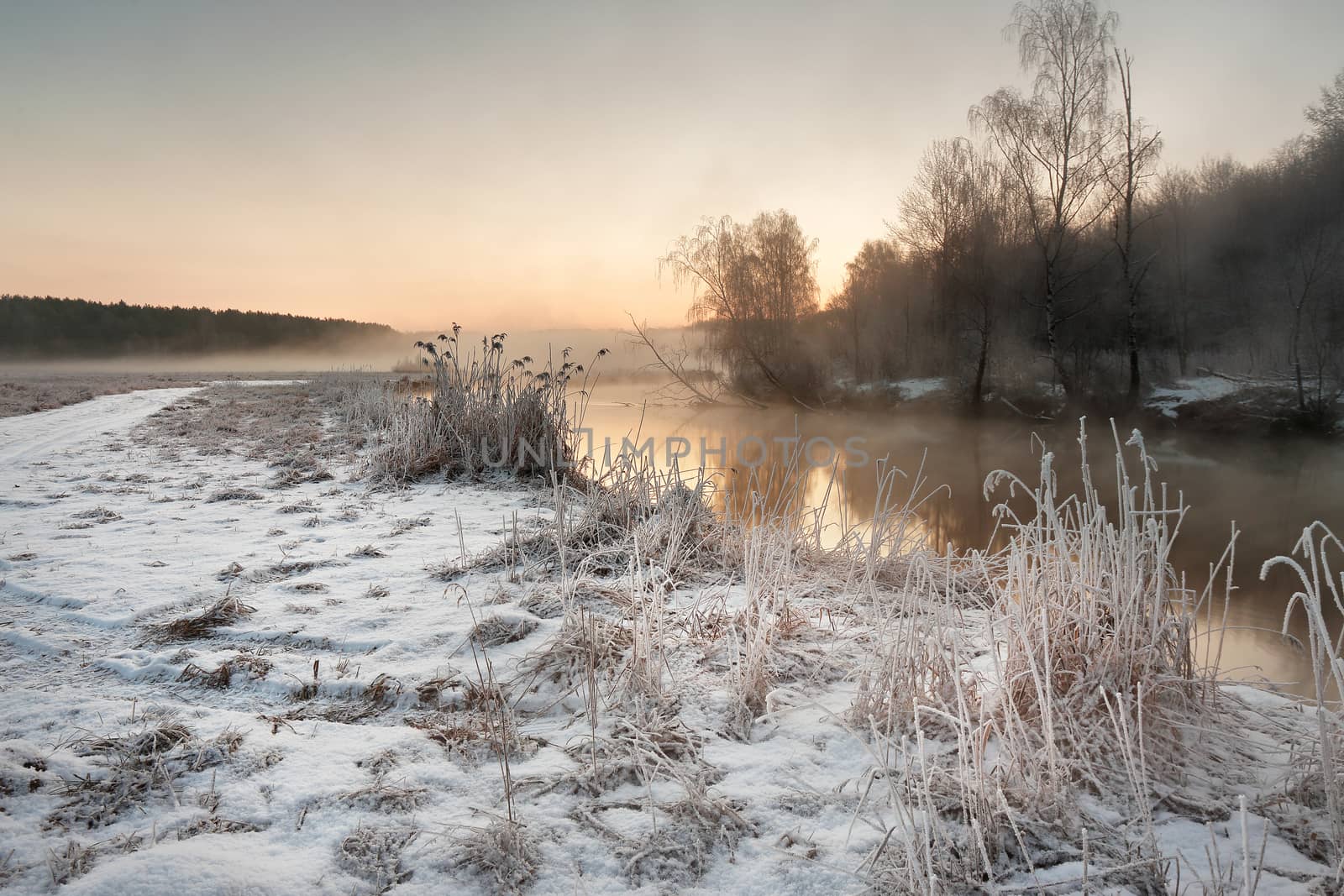 Winter misty dawn on the river. Rural foggy and frosty scene in Belarus