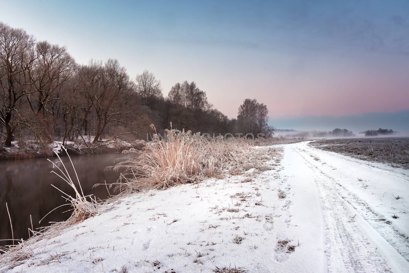 Winter misty dawn on the river. Rural foggy and frosty scene in Belarus