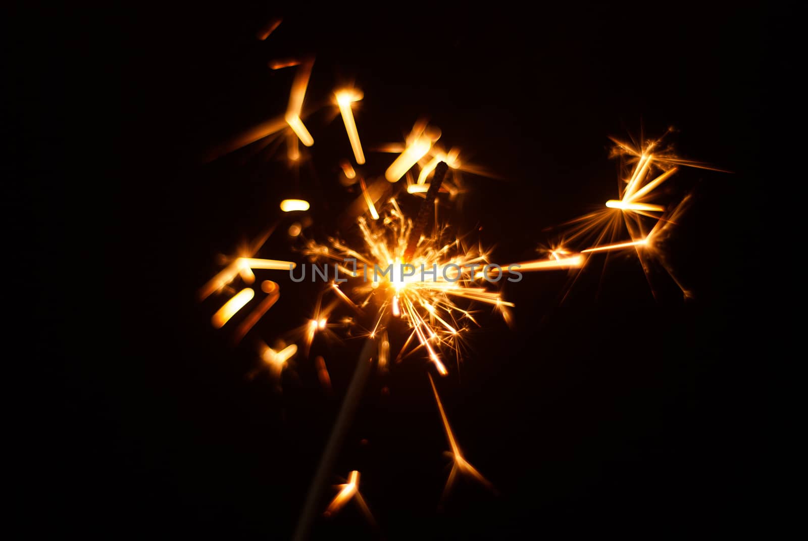 Sparkler on a black background, sparks fly in different directions, Christmas atmosphere
