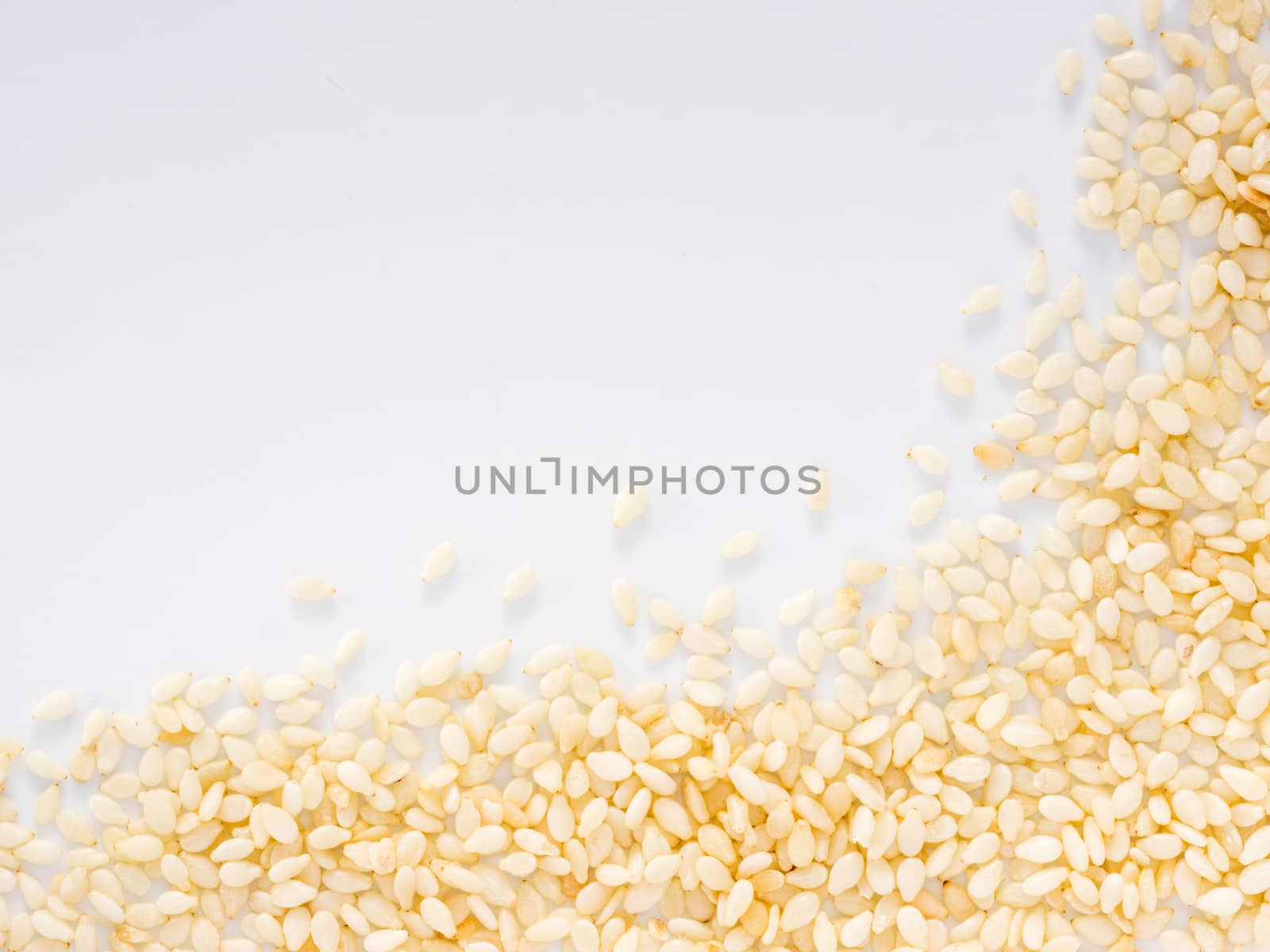 Sesame Seeds on white background with copy space. Isolated one edge. Top view or flat lay.
