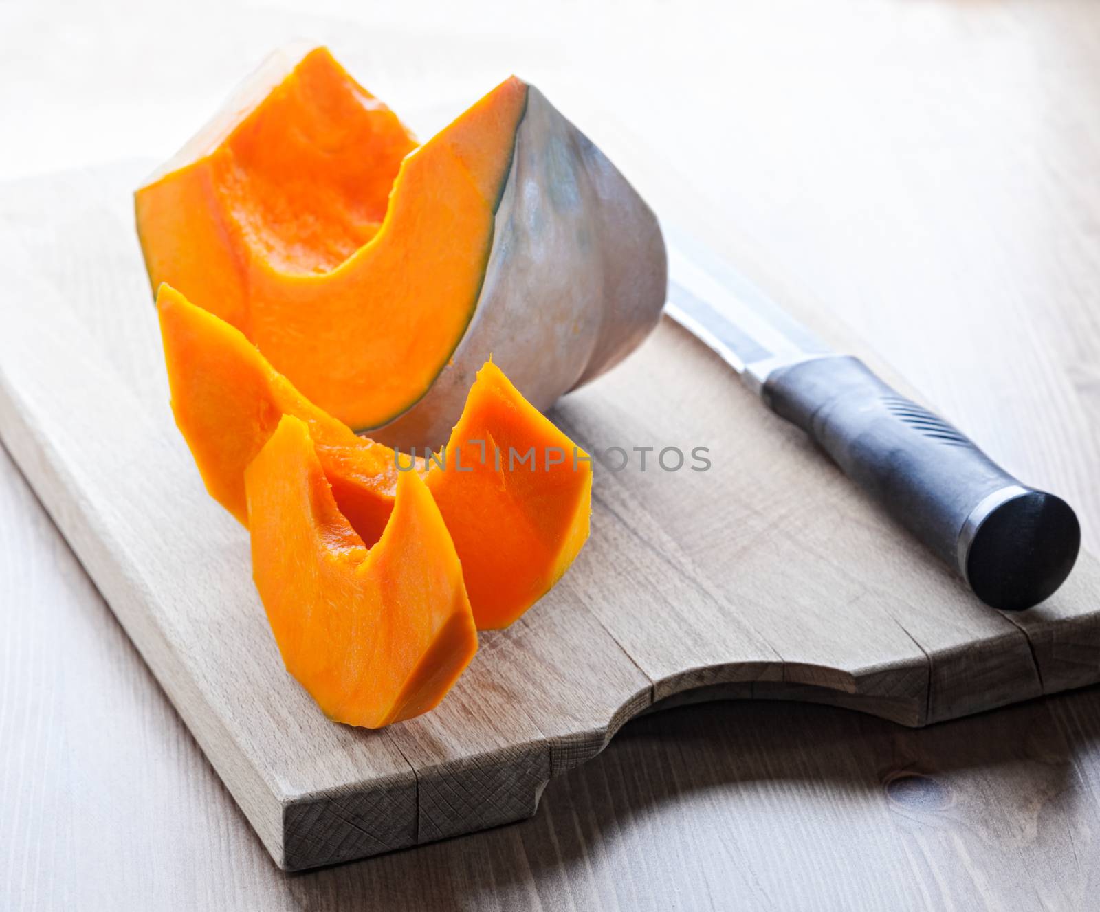 Sliced Pumpkin and knife on a wooden board by supercat67